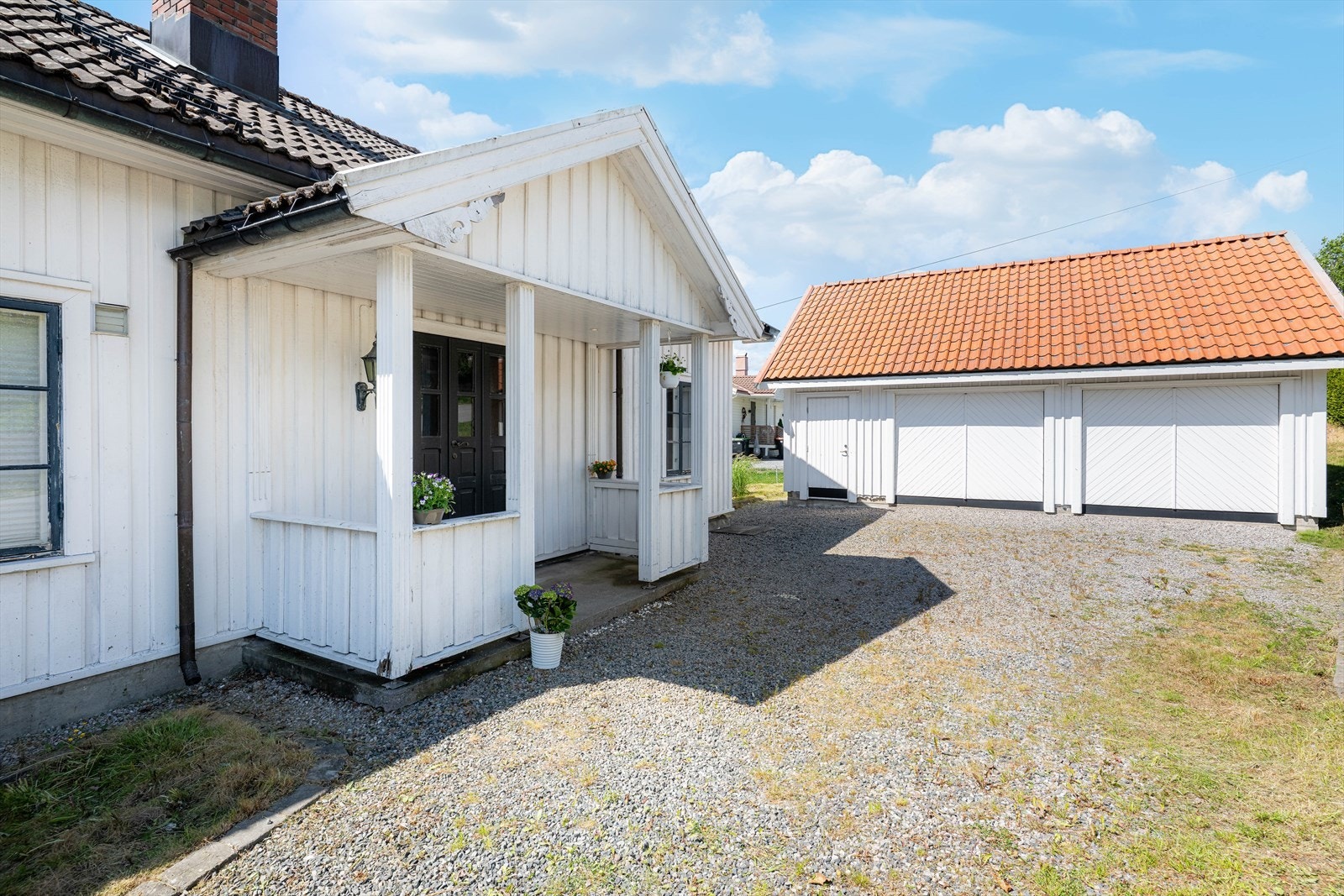 Inngangspartiet er pent og overbygget med støpt såle og tett rekkverk.
Her er det parkeringsmuligheter på gruslagt gårdsplass like ved inngangsdøren. Galleribilde