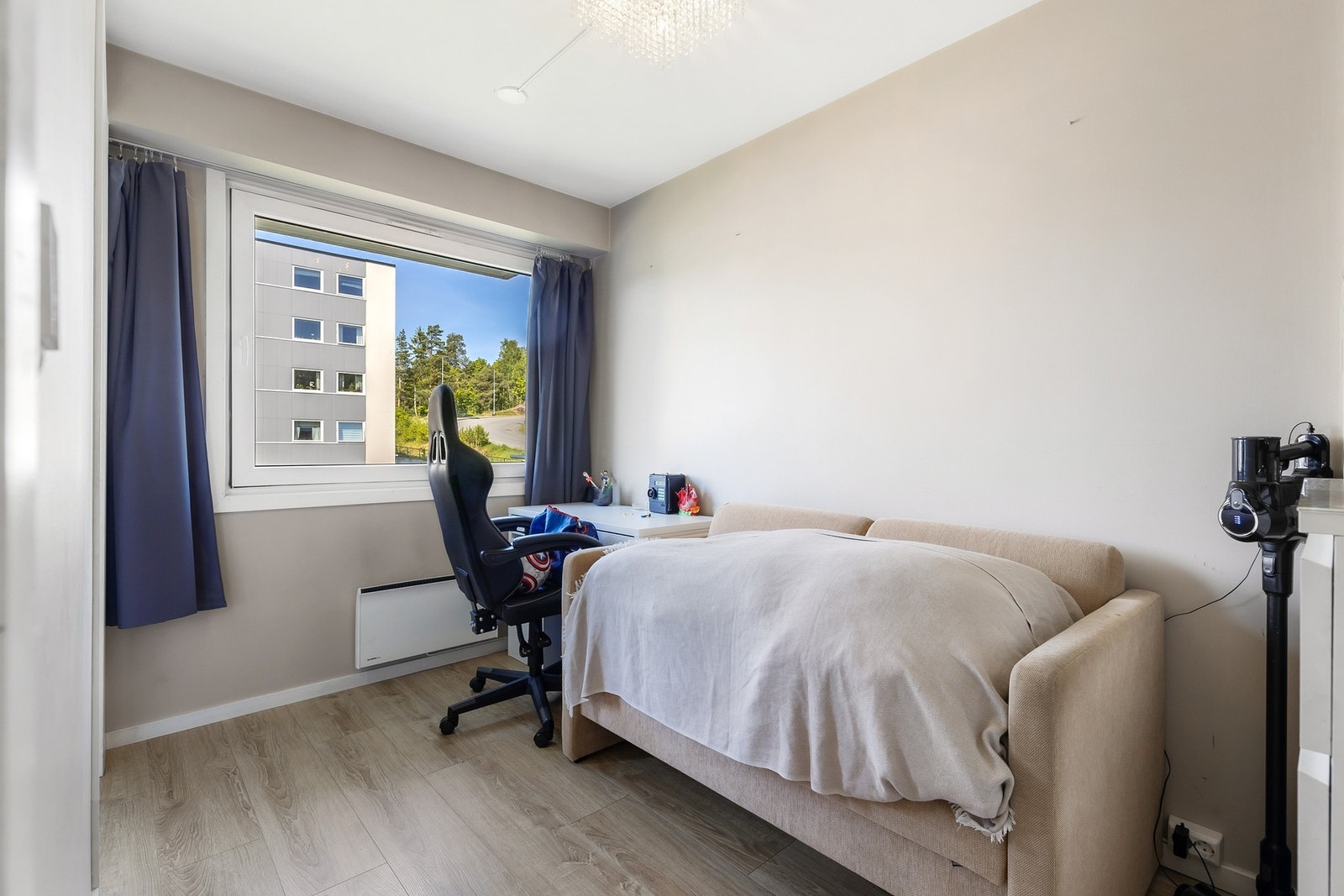 Lyst soverom med fin plass til seng og garderobeskap Galleribilde