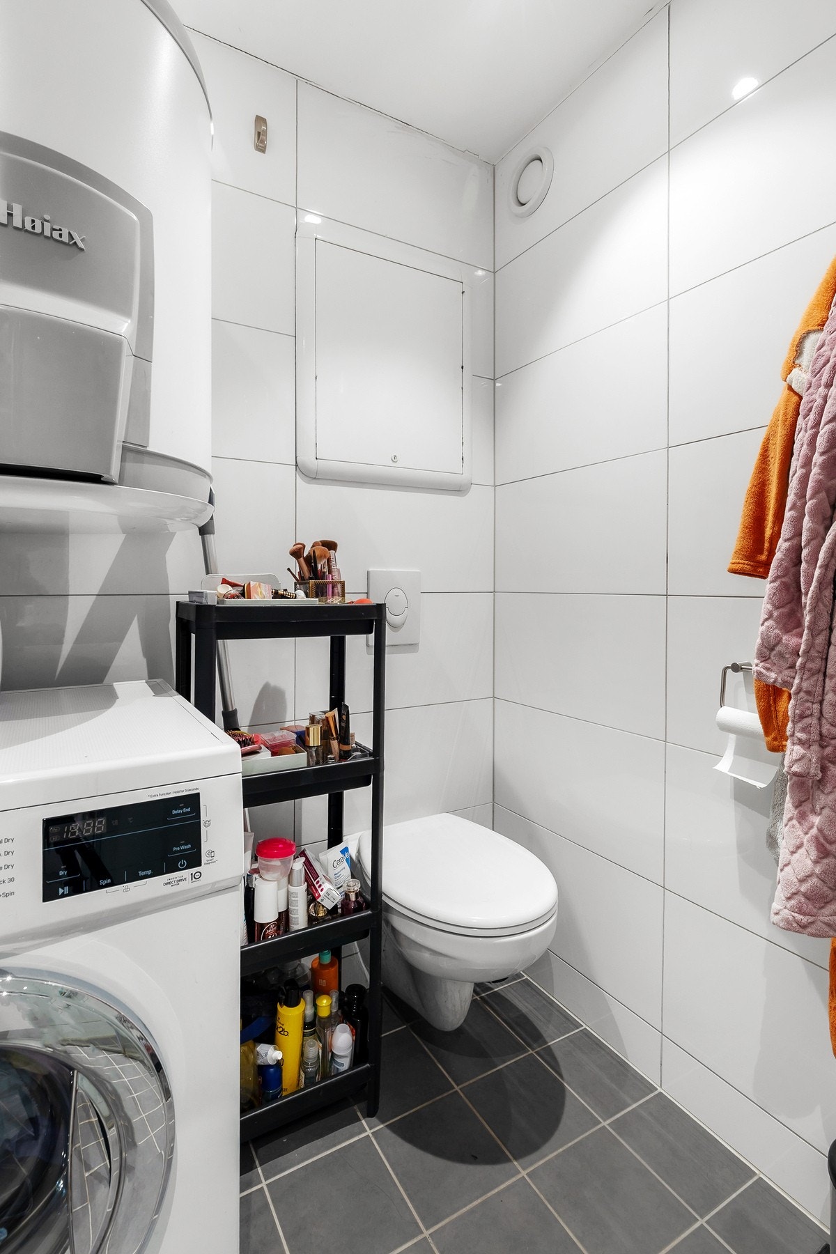 Toalettet er vegghengt og det er opplegg for vaskemaskin Galleribilde