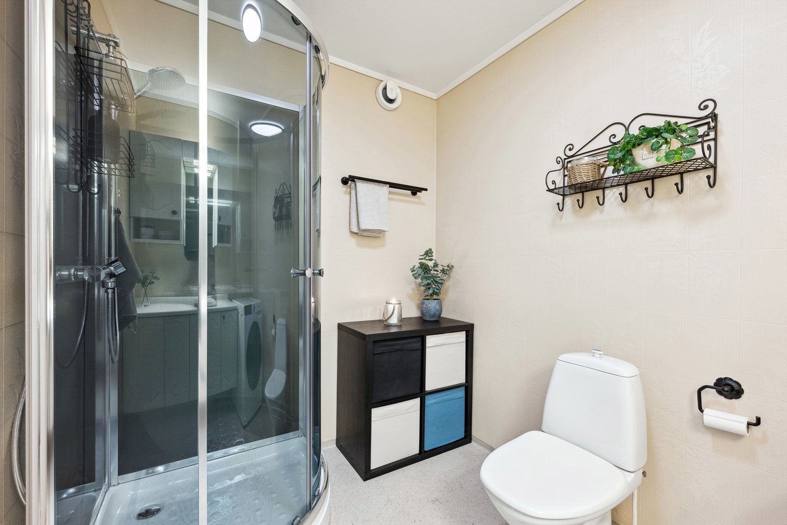 Pent bad med dusjkabinett, wc, opplegg for vaskemaskin og stor baderomsinnredning med mye skapplass. Galleribilde