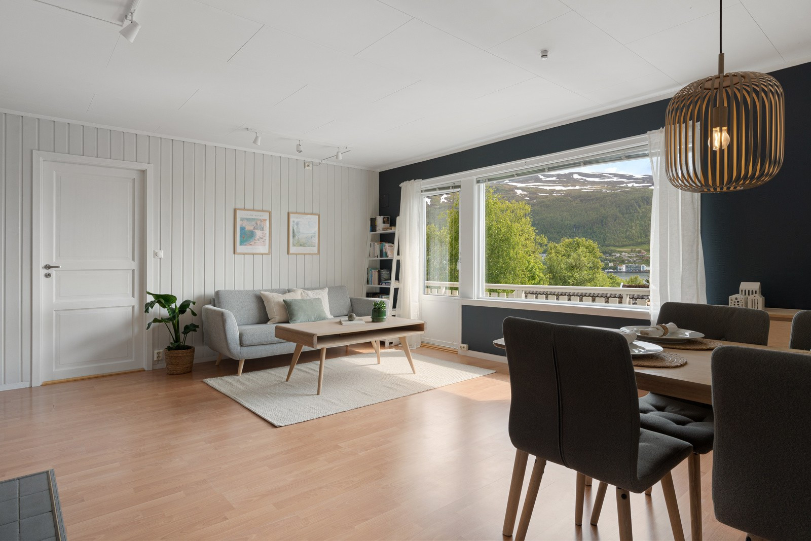 Stuen er delvis adskilt fra kjøkkenet og rommet har god plass til både spisebord og sofagruppe.