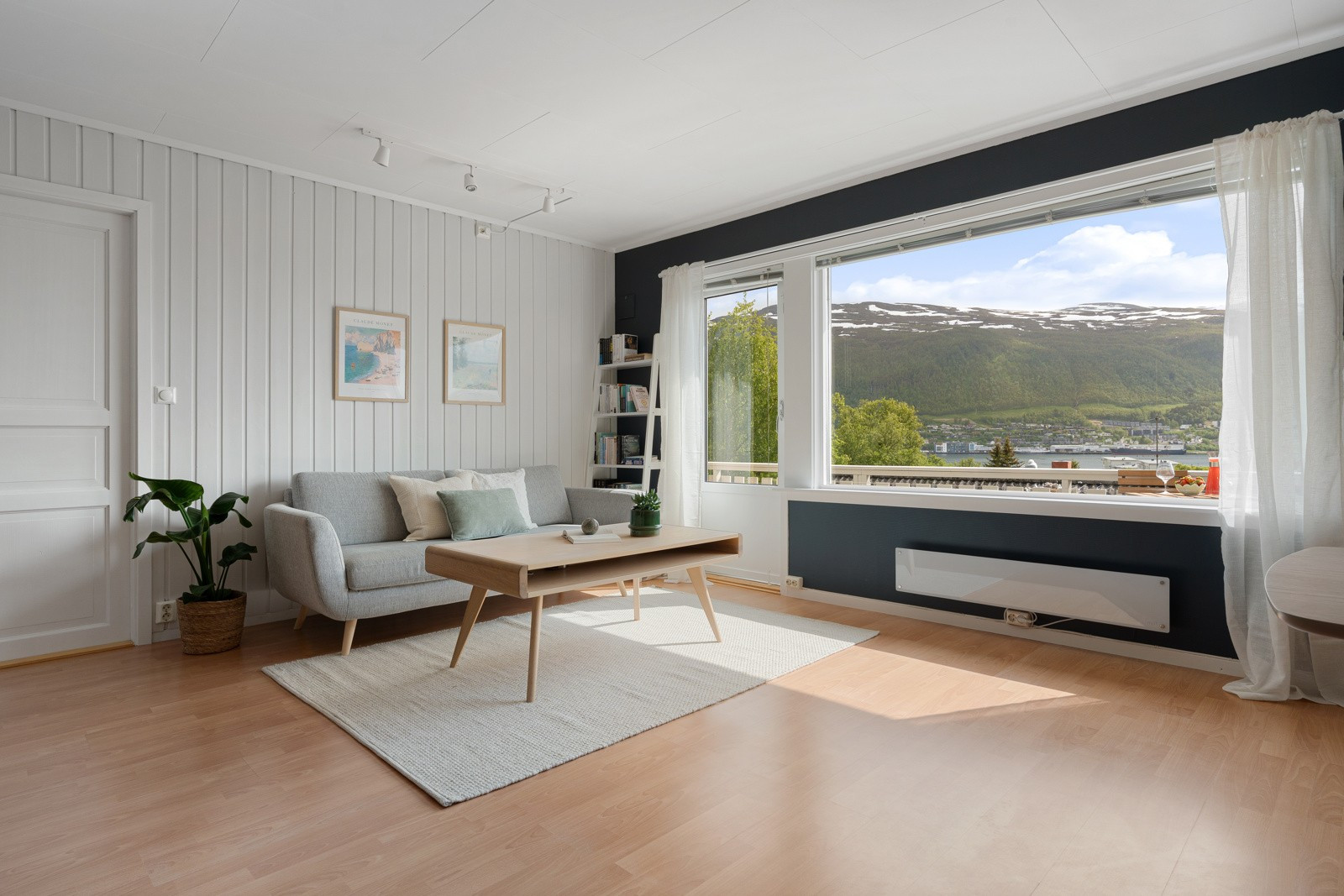 Stue med store vindusflater som gir rikelig lysinnslipp.