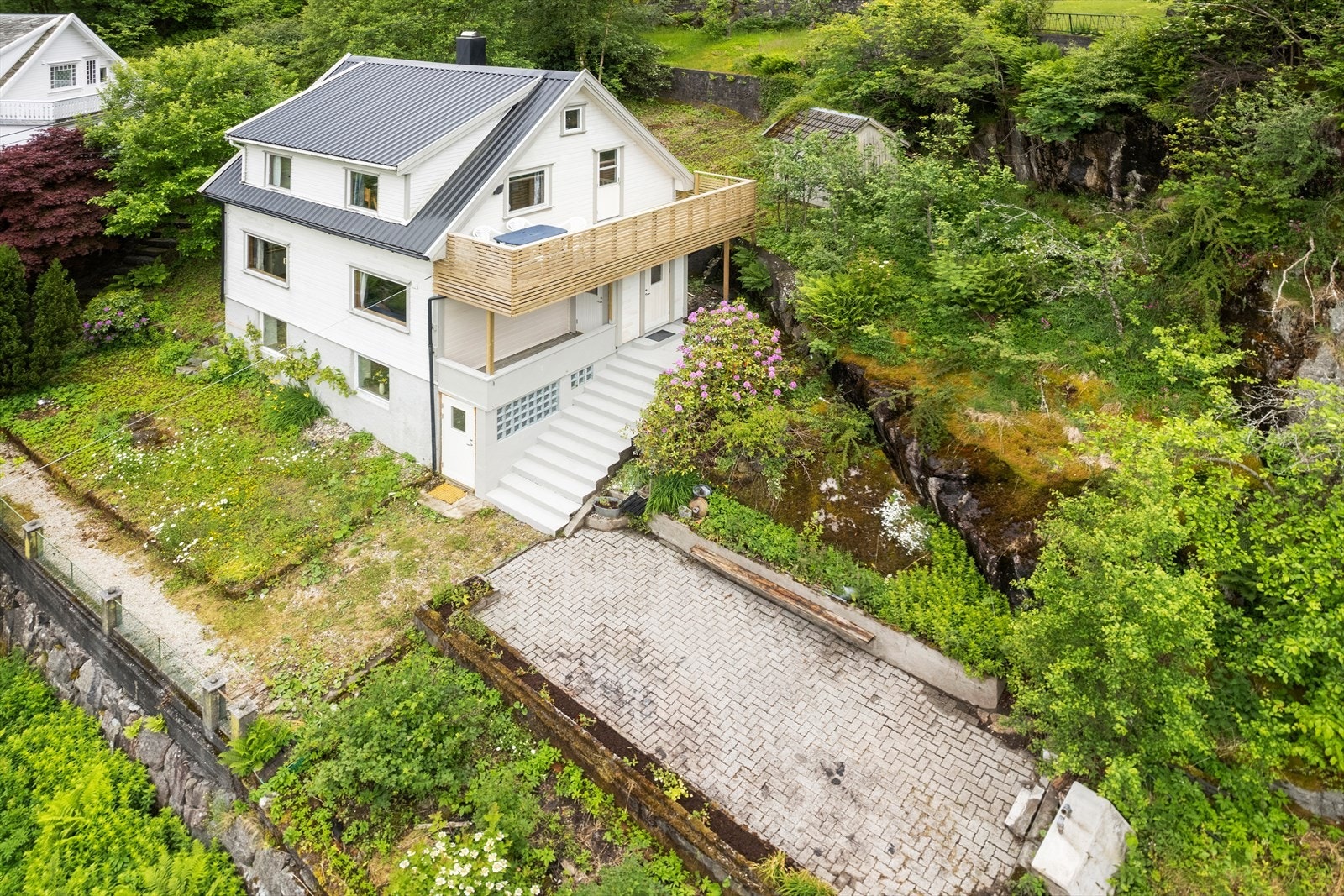 Eiendommen er opparbeidet med hage med plen og noe beplantning. Galleribilde