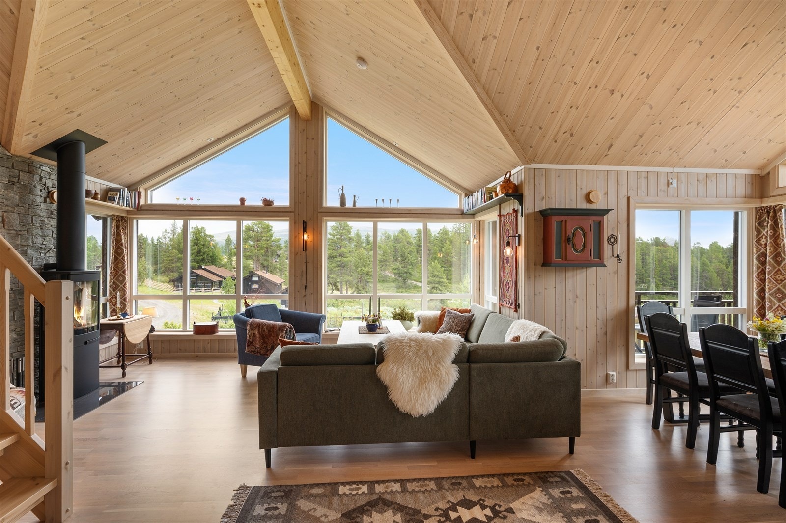 De store vindusflatene kombinert med høy skråhimling, gir rikelig med lys og luft til den romslige stuen. Galleribilde