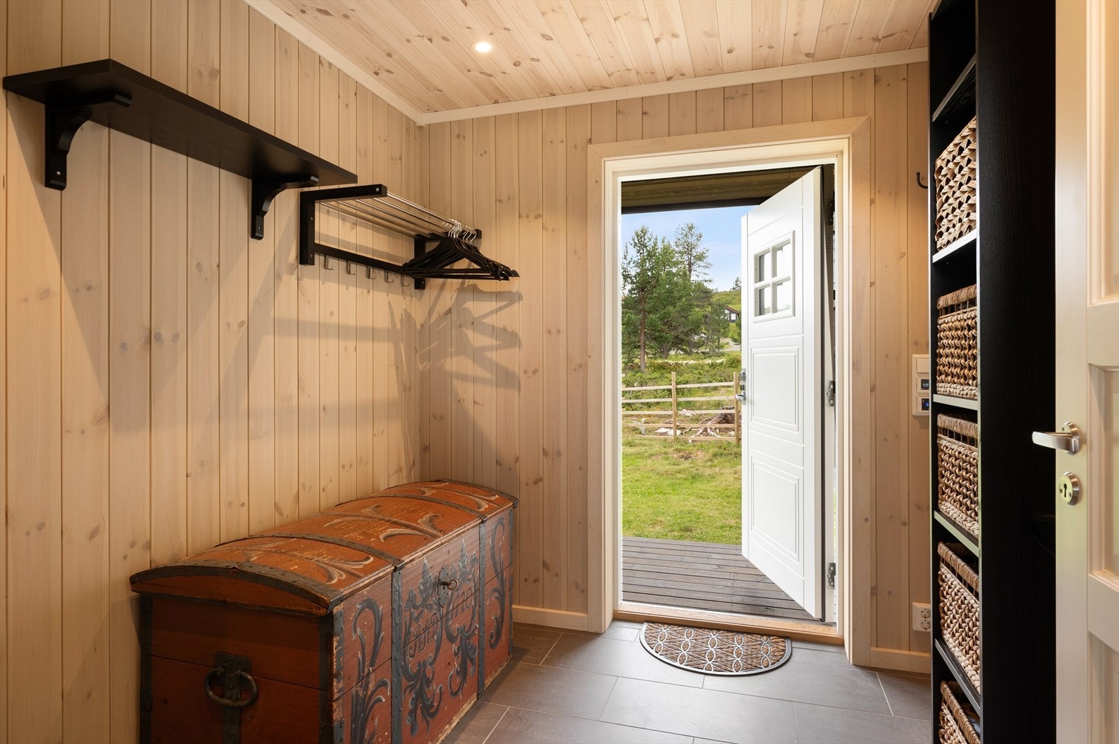 Flislagt entré i panel vegger- og himling. Downlights og lyse farger i entréen gir hytta et godt førsteinntrykk. Galleribilde