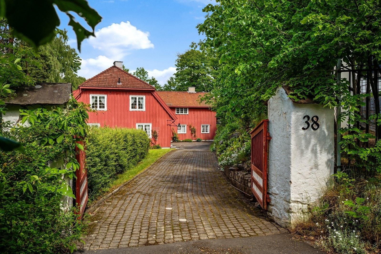Eiendommen Evenstad består av en stort, herskapelig panelt trevilla (hovedhuset) med sidebygning i to etasjer Galleribilde