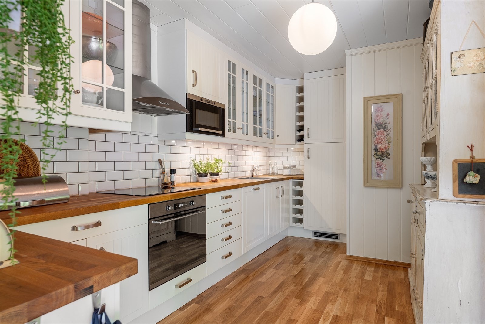 Kjøkkeninnredning fra 2015 med benkeplater av heltre, flislagt backsplash, profilerte fronter og ventilator med utkast til friluft. Galleribilde