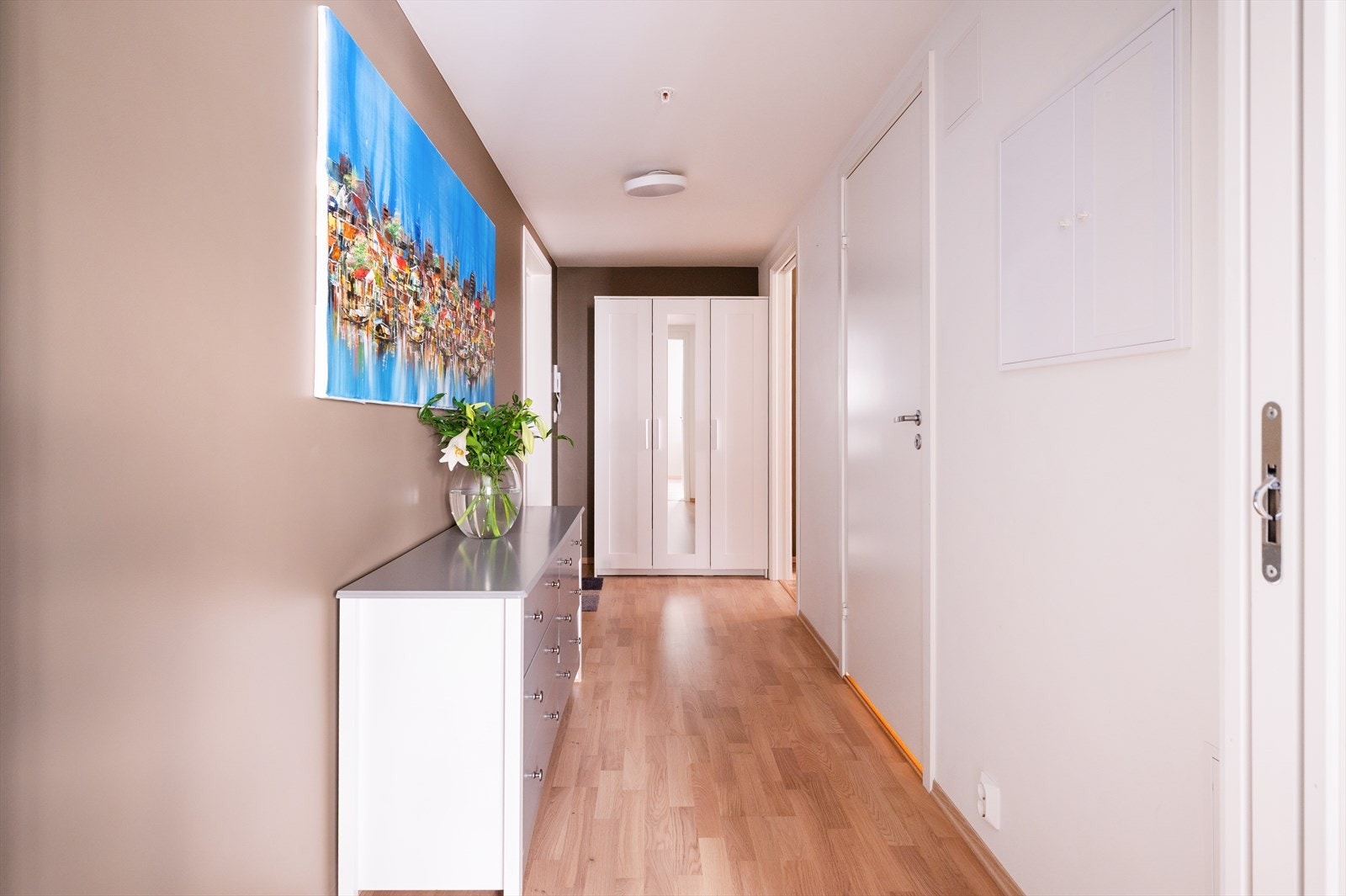 Romslig og innbydende entré med plass til oppheng av yttertøy og skjenk for oppbevaring. Galleribilde