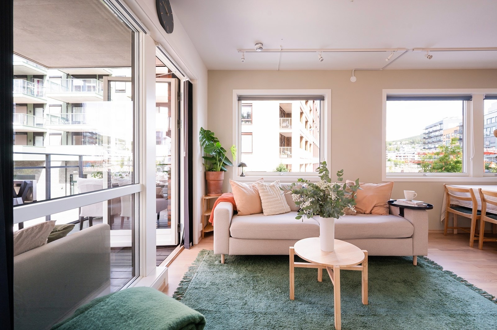 Lys og romslig stue med store vindusflater fra to retninger som gir rikelig med naturlig dagslys og en luftig atmosfære. Galleribilde