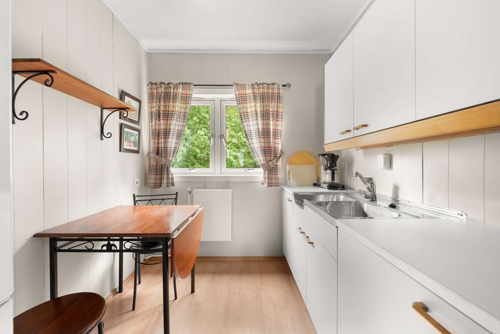 Belysning er montert over benken, og over kokesonen har kjøkkenet en ventilator. Det er avsatt plass til komfyr og kjøleskap. Galleribilde