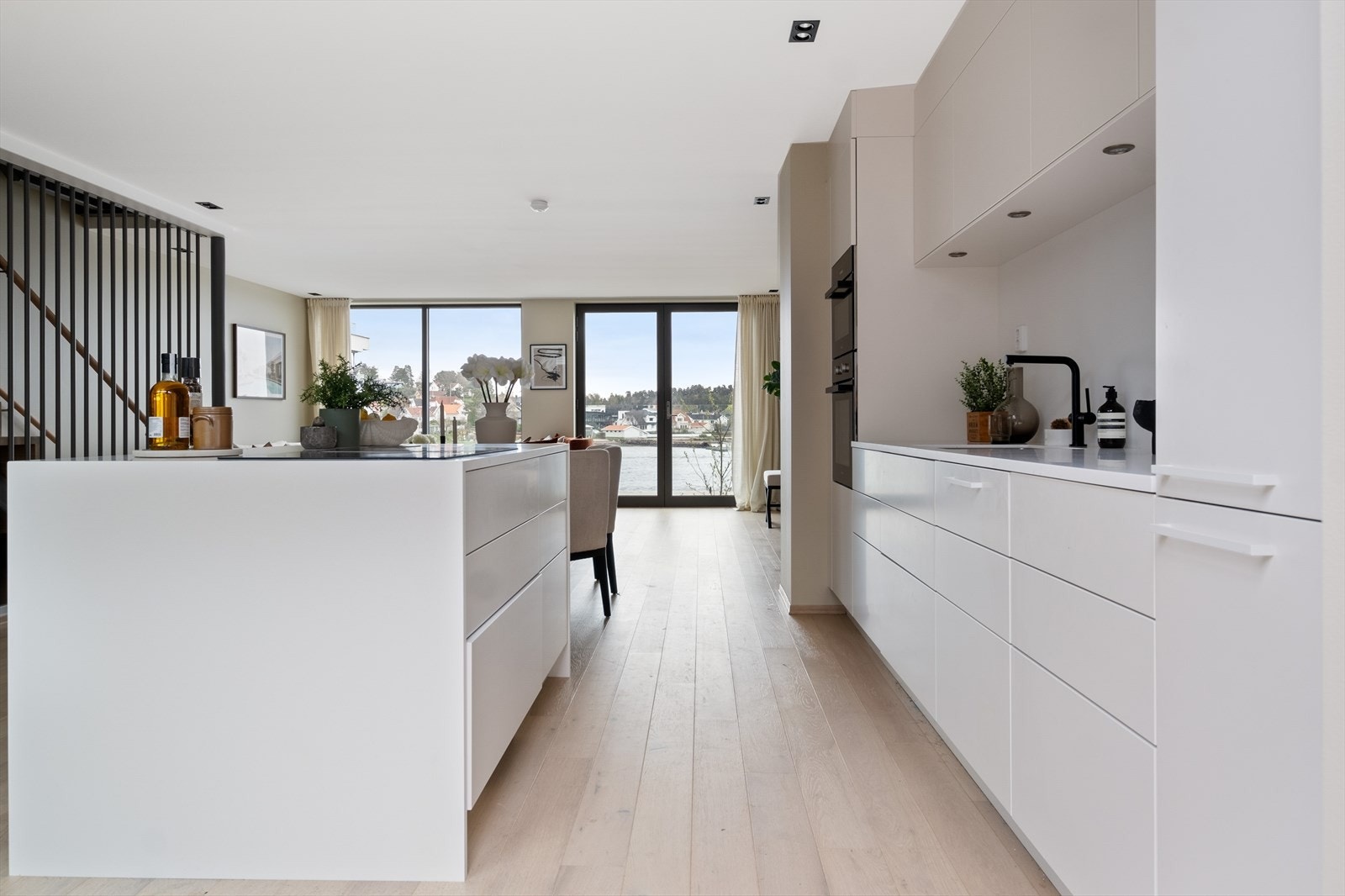 Stilren innredning med glatte, hvite fronter og benkeplater i slitesterk Corian Galleribilde