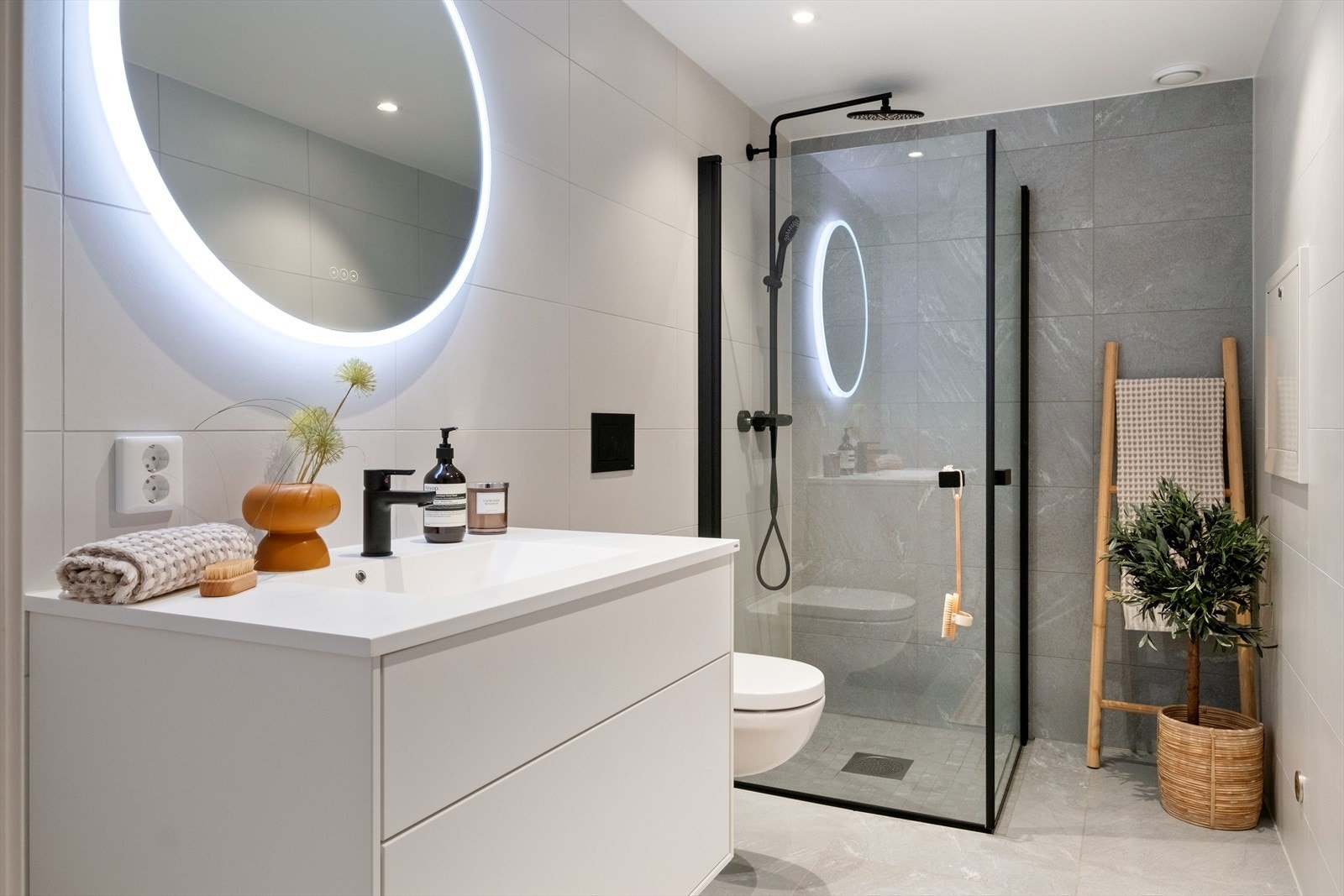 Innredningen er fra Uno Form og består av baderomsmøbler med skuffer, heldekkende servant og rundt speil med integrert lys Galleribilde