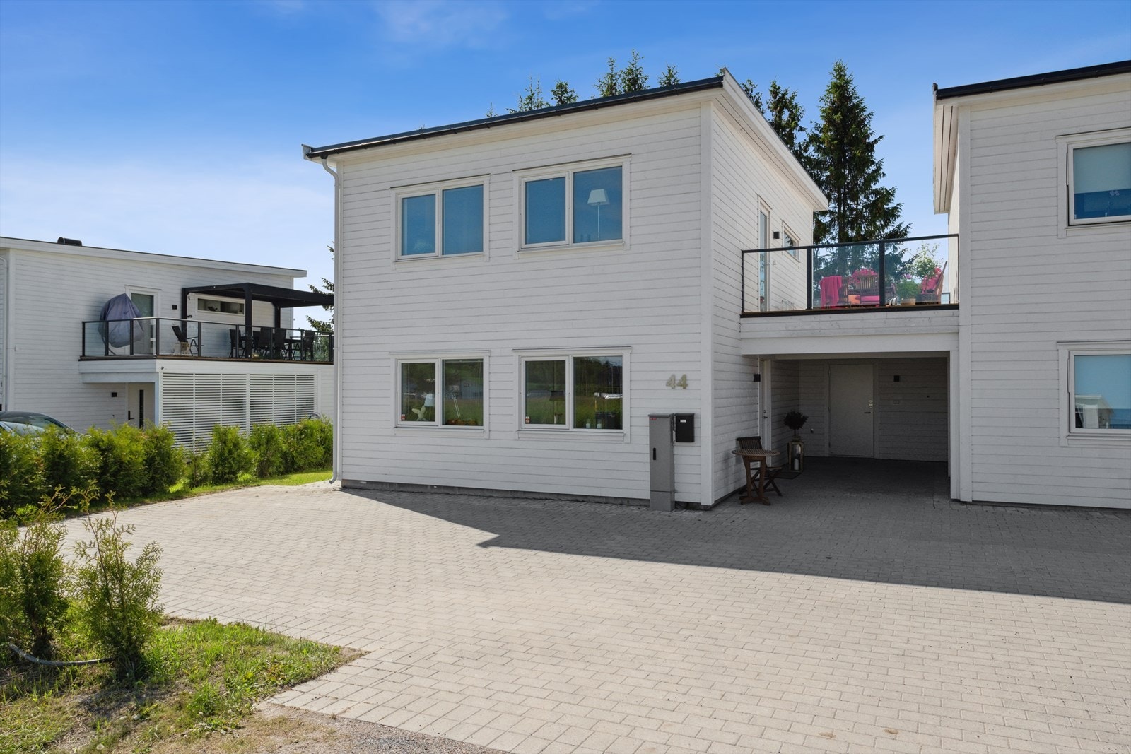 Stor gårdsplass med belegningstein, integrert carport. Galleribilde