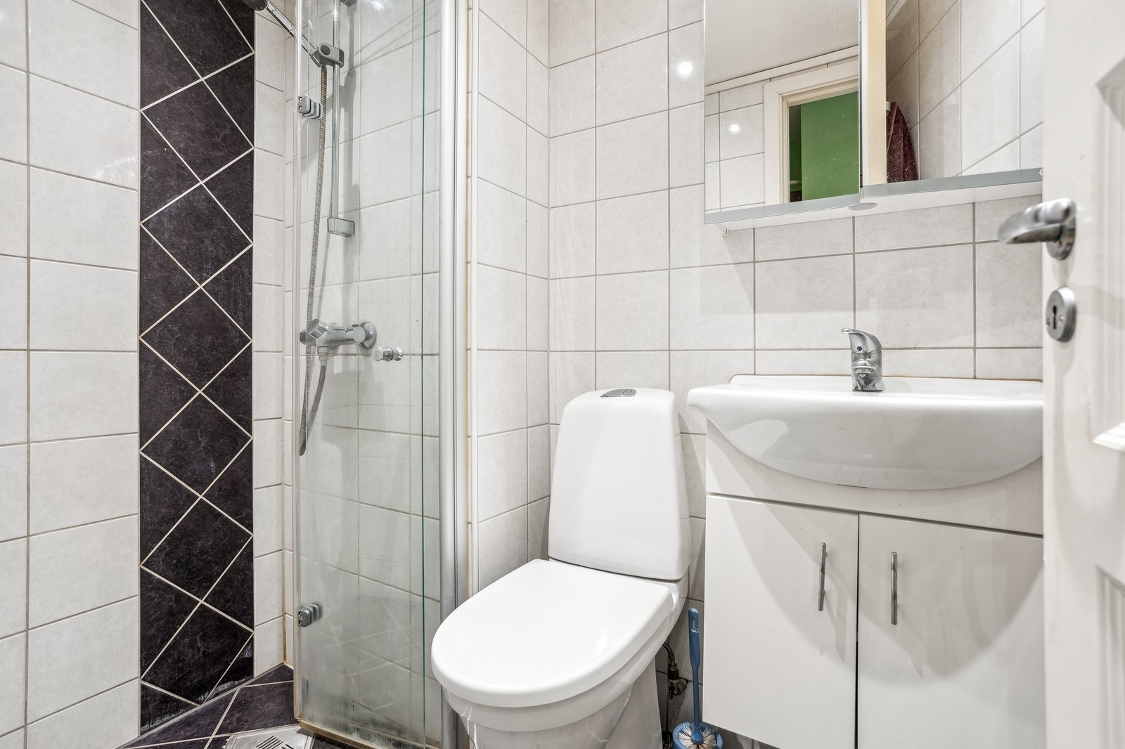 Badet er helfliset og inneholder dusj, toalett, servant. Varmekabler i gulv og downligts i himling Galleribilde