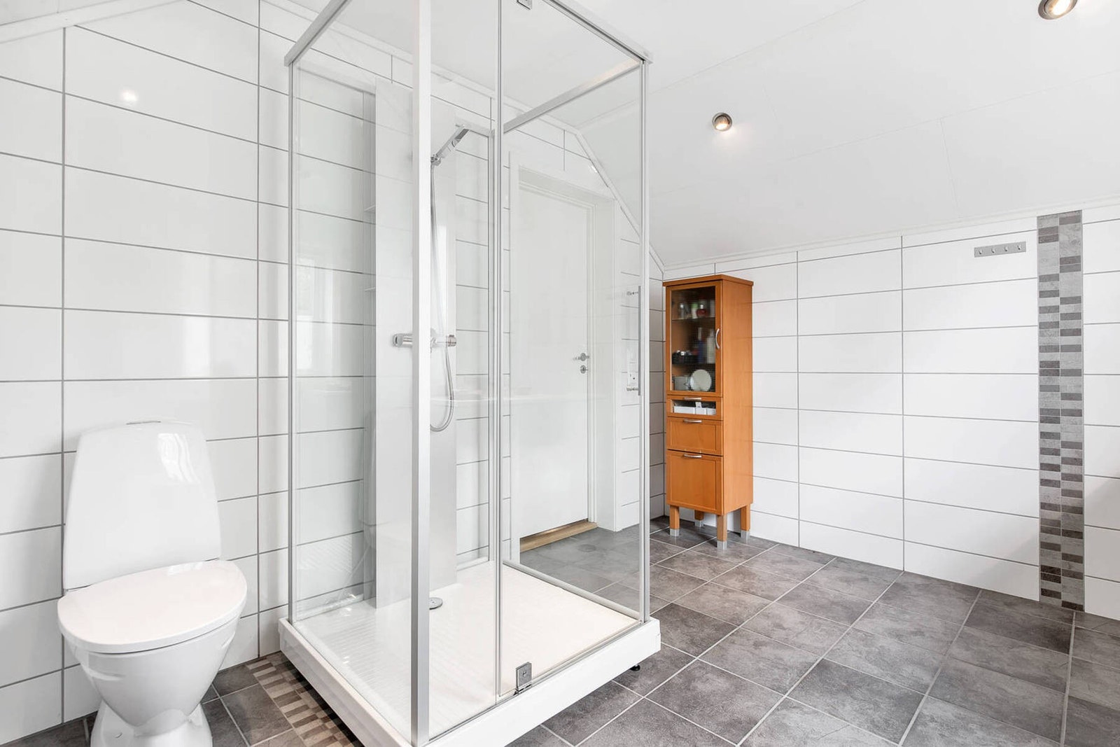 Badet er blant annet utstyrt med to servanter, wc, dusjkabinett samt gulvvarme. Galleribilde