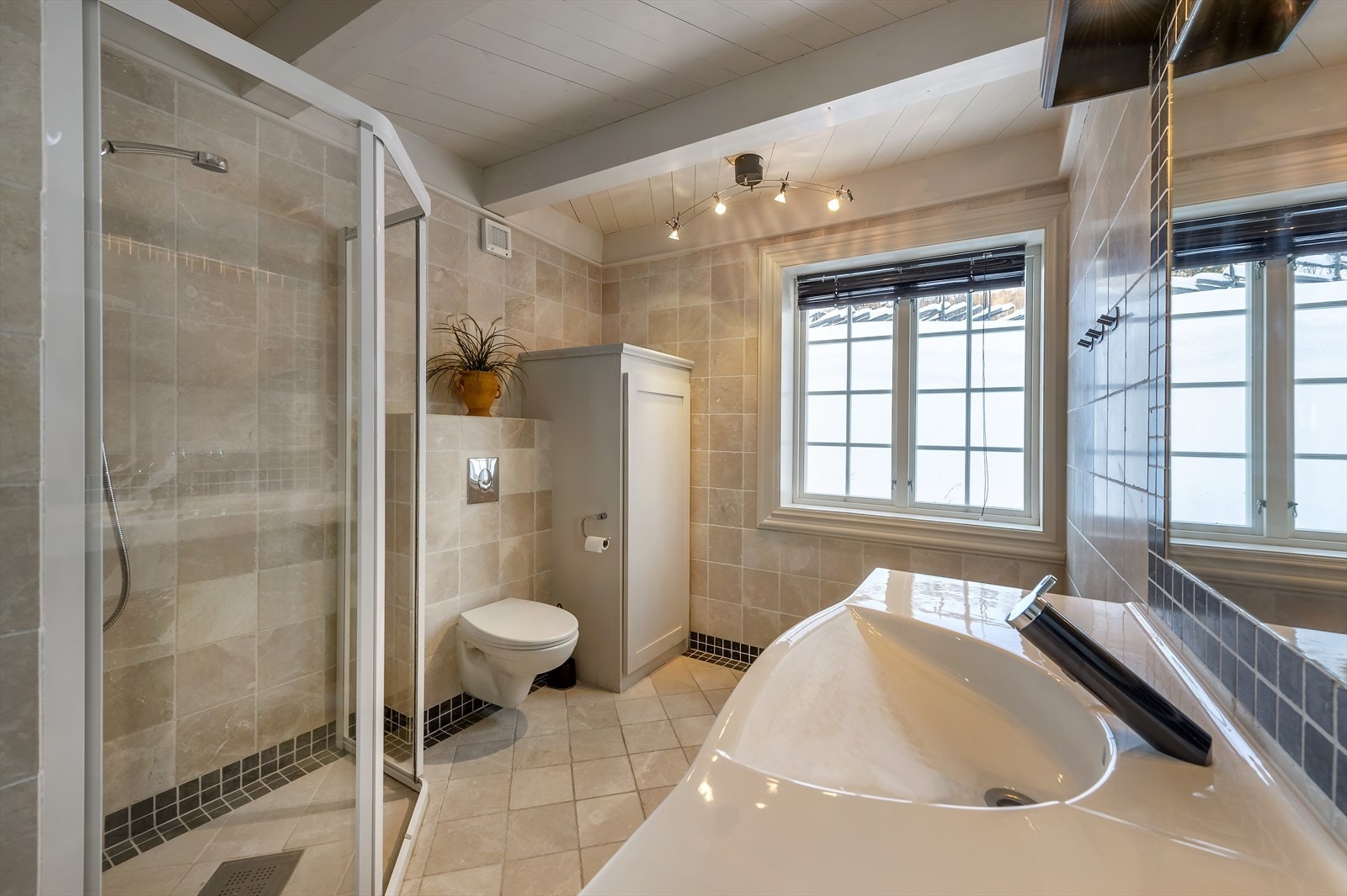 Badet har gulvvarme, innredning i heltre, dushjørne og vegghengt wc Galleribilde