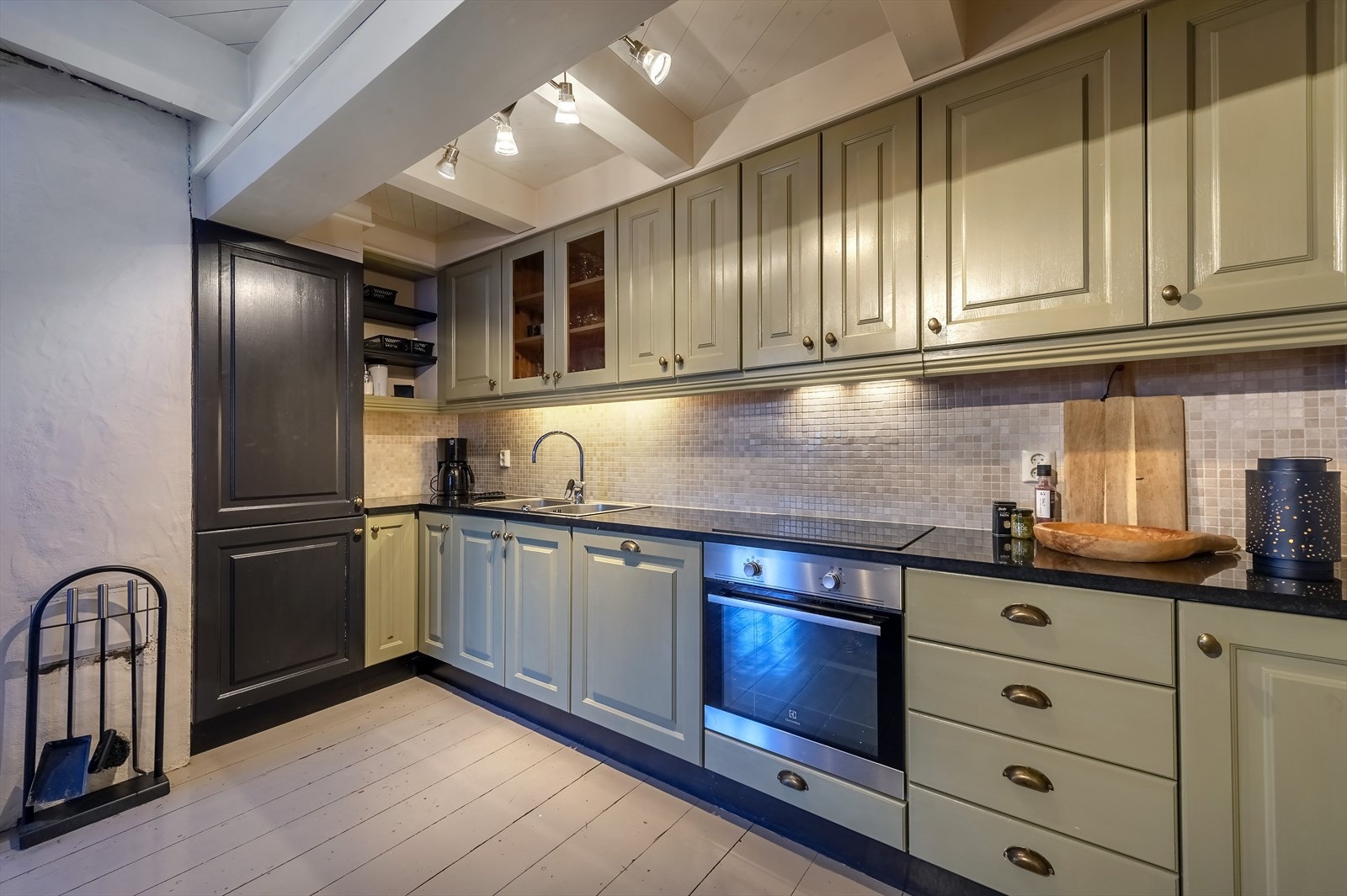 Kjøkkeninnredning i heltre med benkeplater i granitt og marmor mosaikkflis på vegg Galleribilde