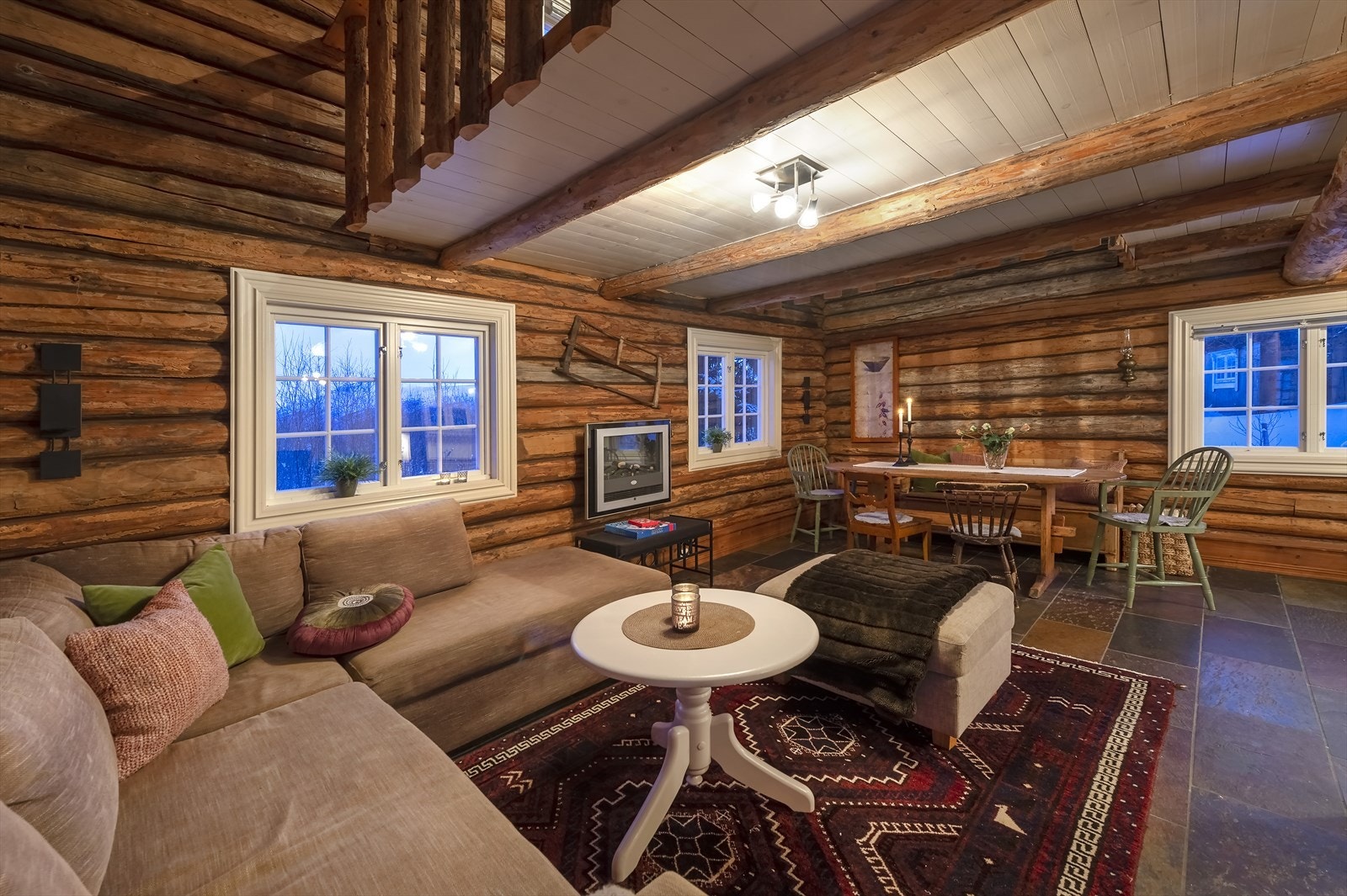 Låven er innredet som gjestehytte med stue, kjøkken og bad i 1. etasje samt en stor hems innredet som soverom/møterom Galleribilde