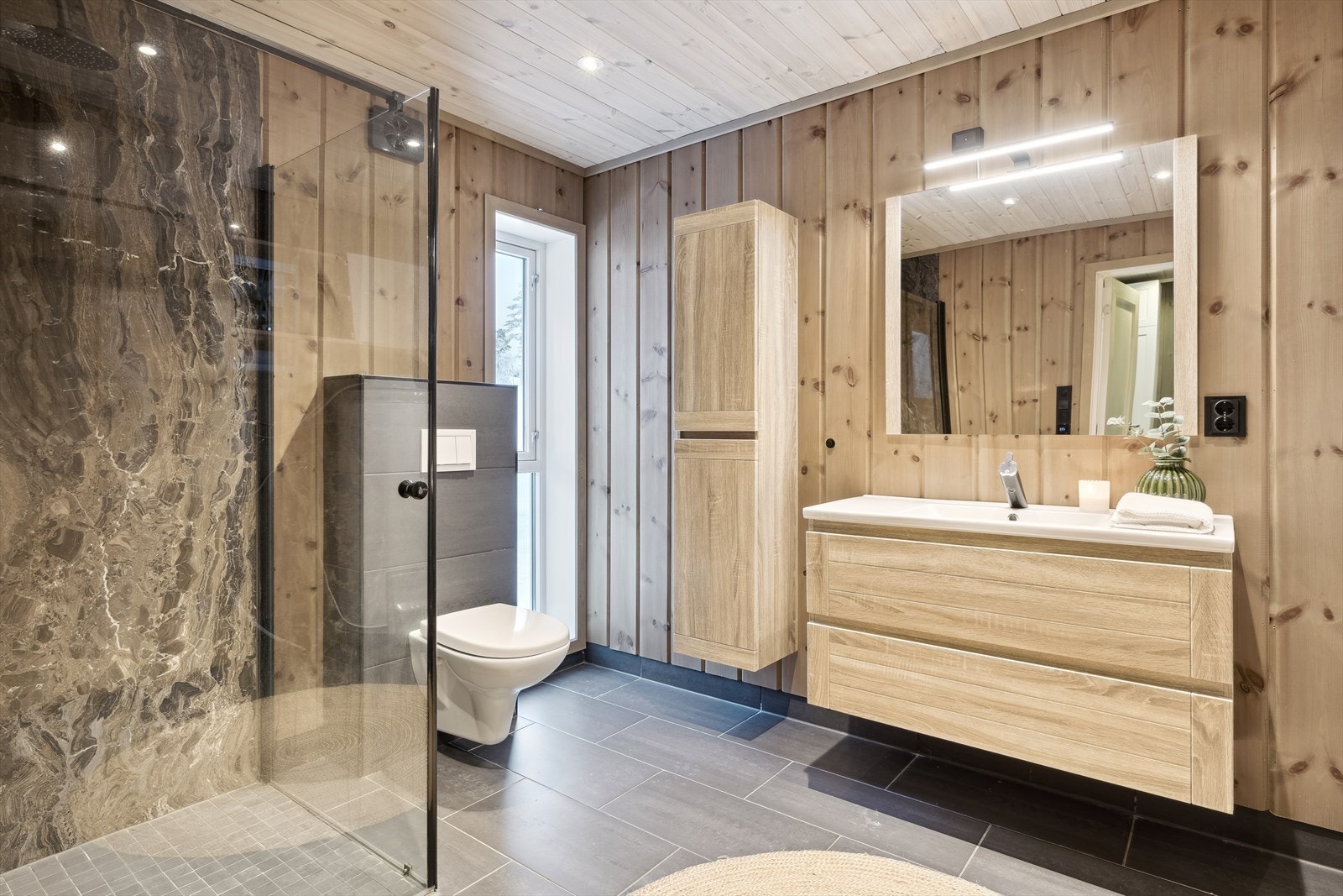 Pent baderom med flislagt gulv og gulvvarme, samt downlights i himling. Galleribilde
