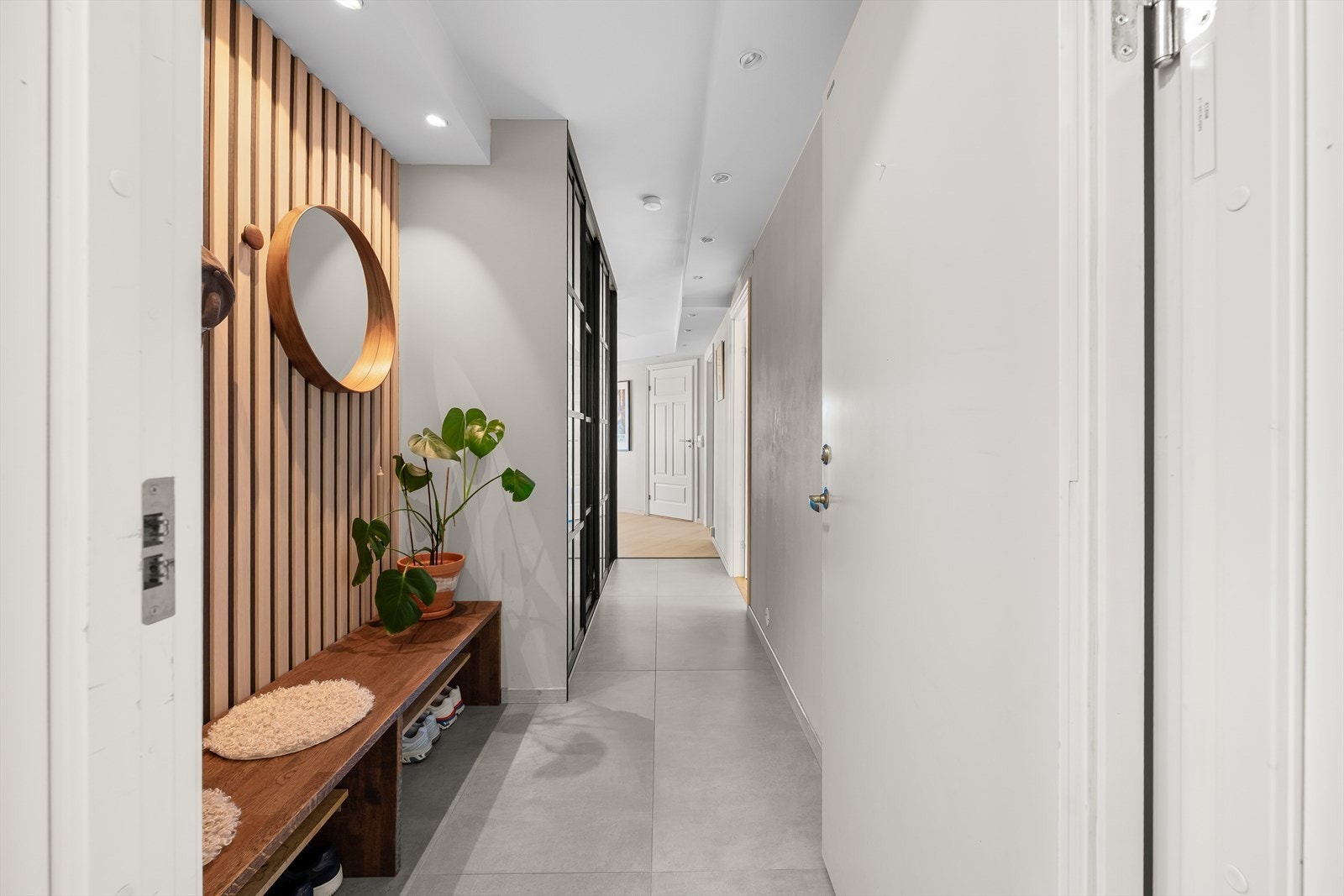 Velkommen inn! Entreen er pent innredet med lekre fliser, lysmalte vegger og en romslig skyvedørsgarderobe. Varmekabler i gulvet. Galleribilde