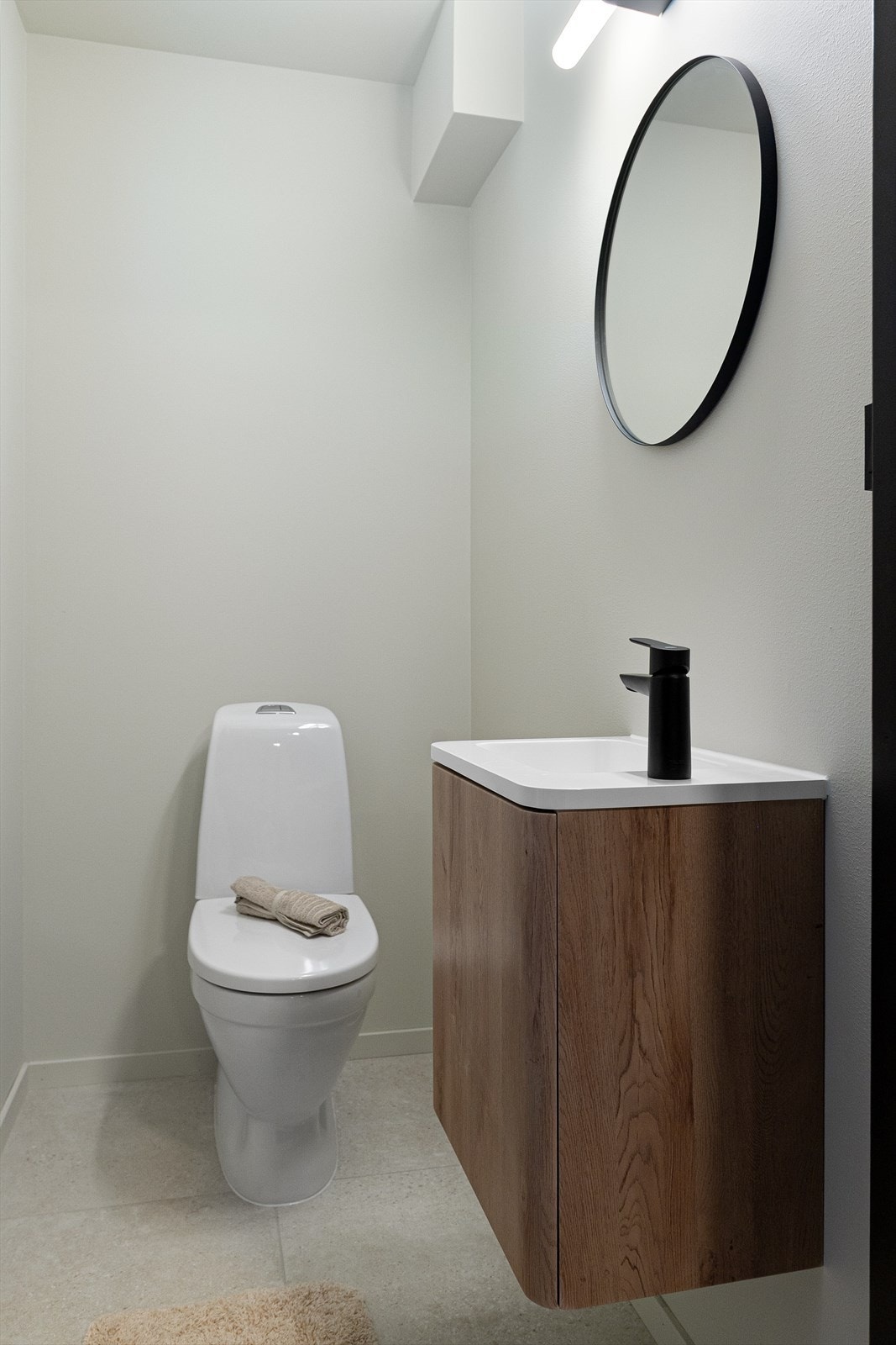 Flotte fliser på gulvet og stilren baderomsinnredning med heldekkende vask. Galleribilde