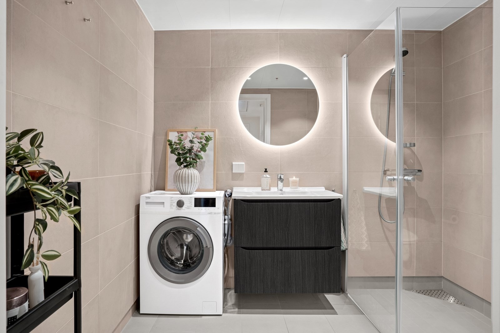Badet er delikat innredet med en kombinasjon av store, grå og beige fliser på gulv og vegger. Gulvet har også varmekabler for ekstra komfort. Galleribilde