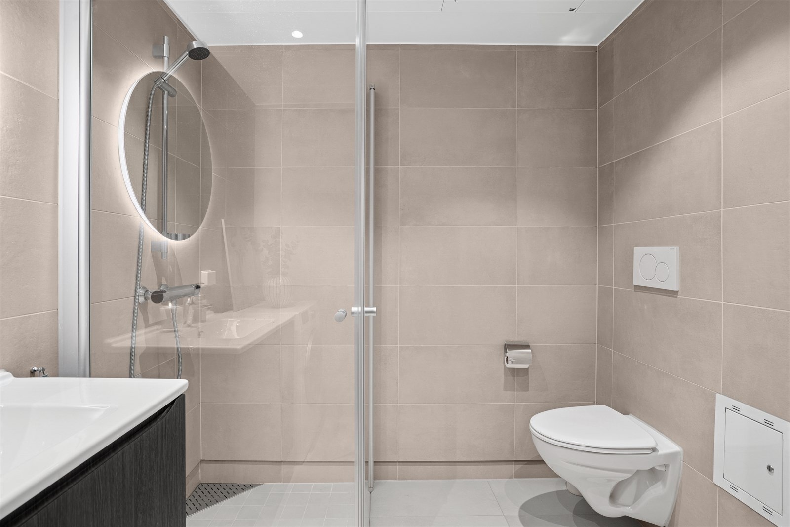 Badet er ellers utstyrt med dusjhjørne, vegghengt toalett og servant med skuffer under. I tillegg har man opplegg for vaskemaskin. Galleribilde