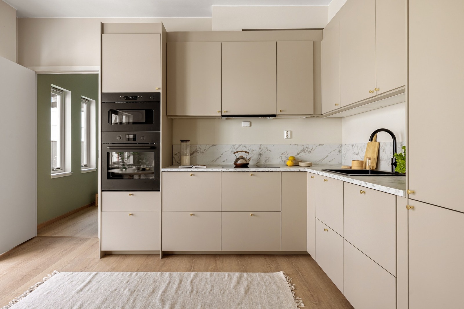 Håndtakene i messingfarget utførelse harmonerer godt med benkeplaten som går videre opp på veggen. Galleribilde