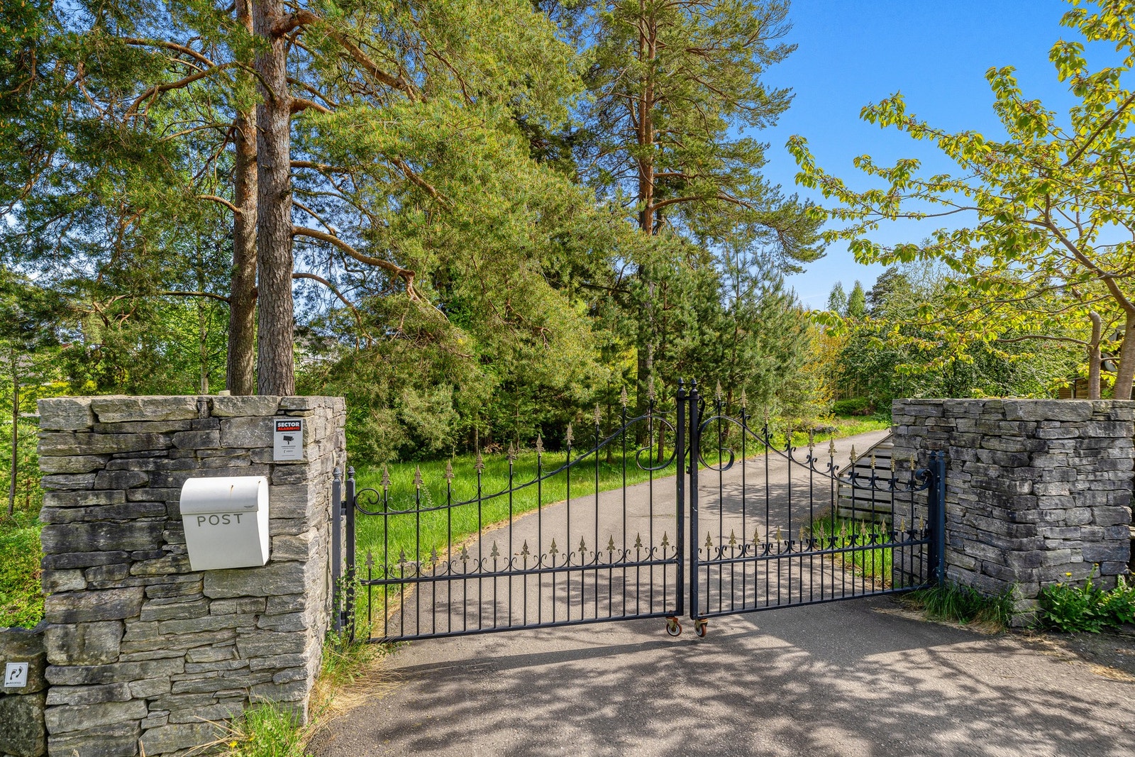 Eiendommen møter deg med en tofløyet smijernsport og flotte portstolper i stablestein ved innkjøringen. Galleribilde
