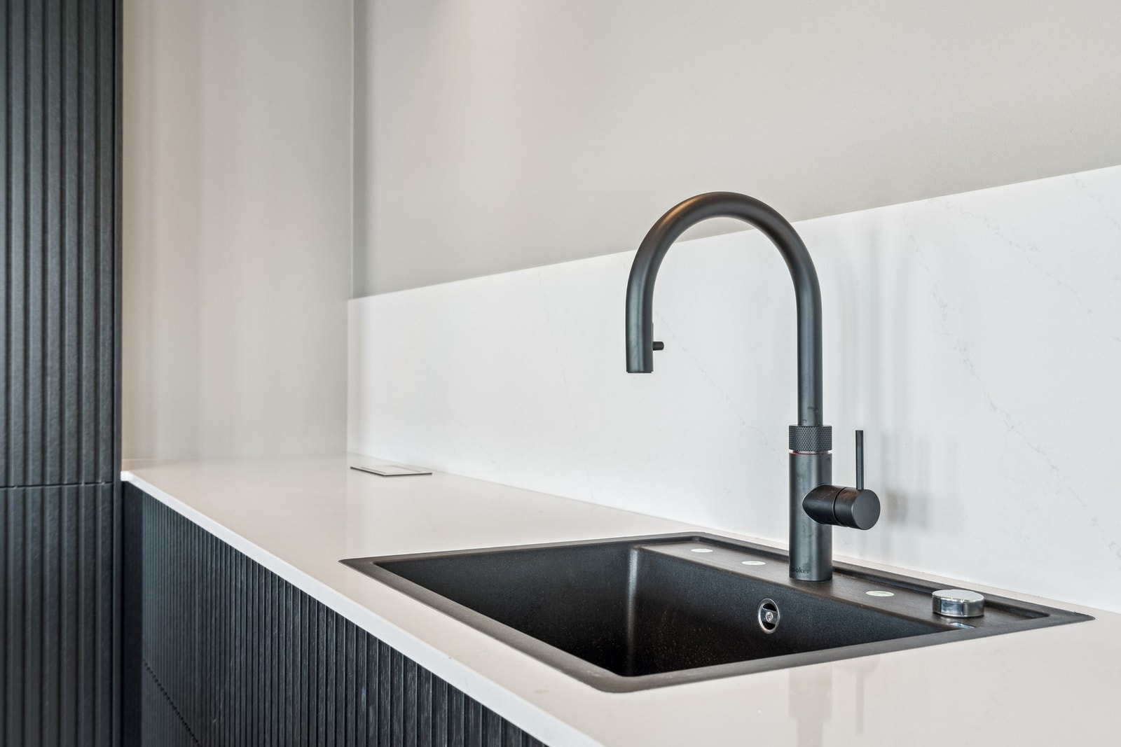 Planlimt sort vask med Quooker-kjøkkenkran som gir både kokende vann og et moderne uttrykk. Galleribilde
