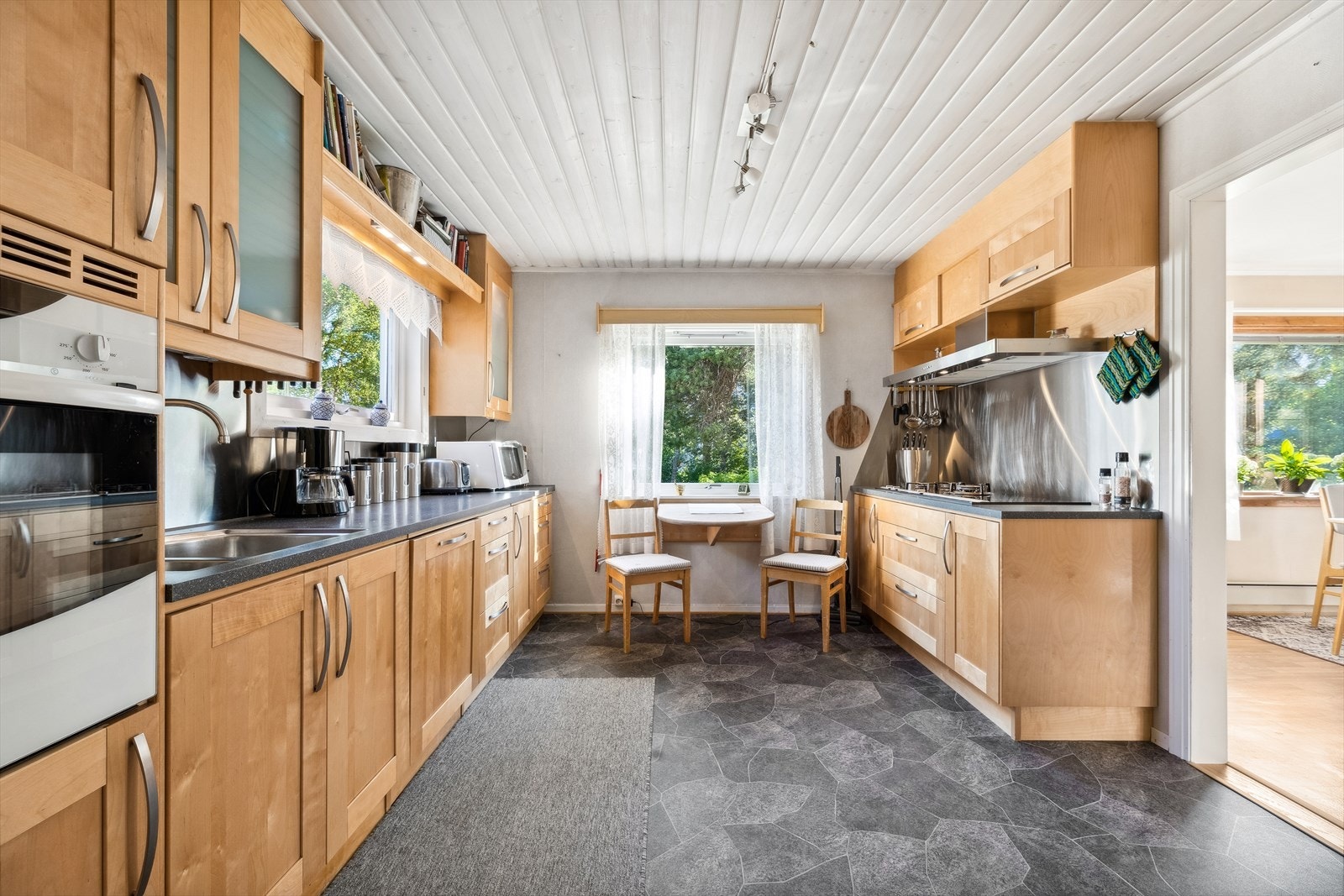 Integrerte hvitevarer som stekeovn, platetopp (med gass og strøm), oppvaskmaskin og kjøleskap. Galleribilde