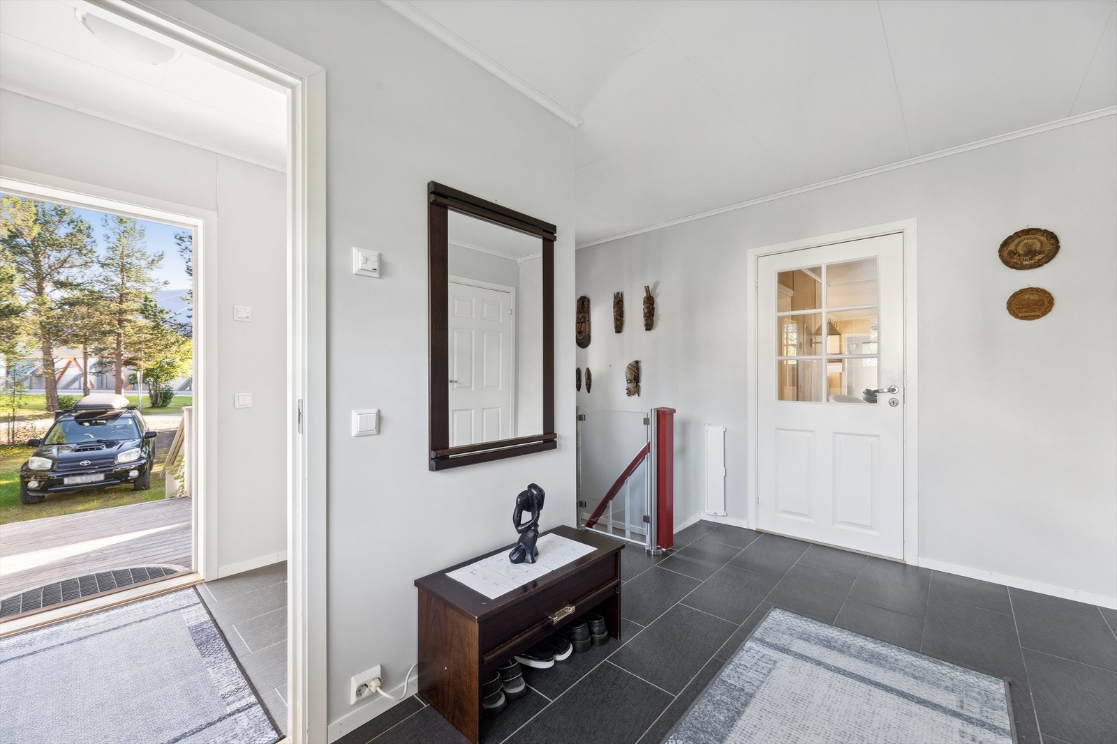 Velkommen inn! Fra en lys entré med skyvedørsgarderobe tar en seg videre inn i en større gang Galleribilde