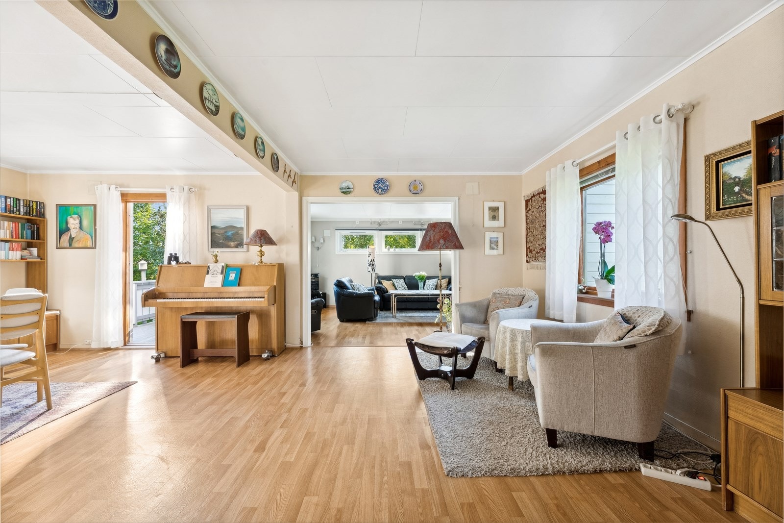 Vi beveger oss inn i en lys og svært romslig stue Galleribilde