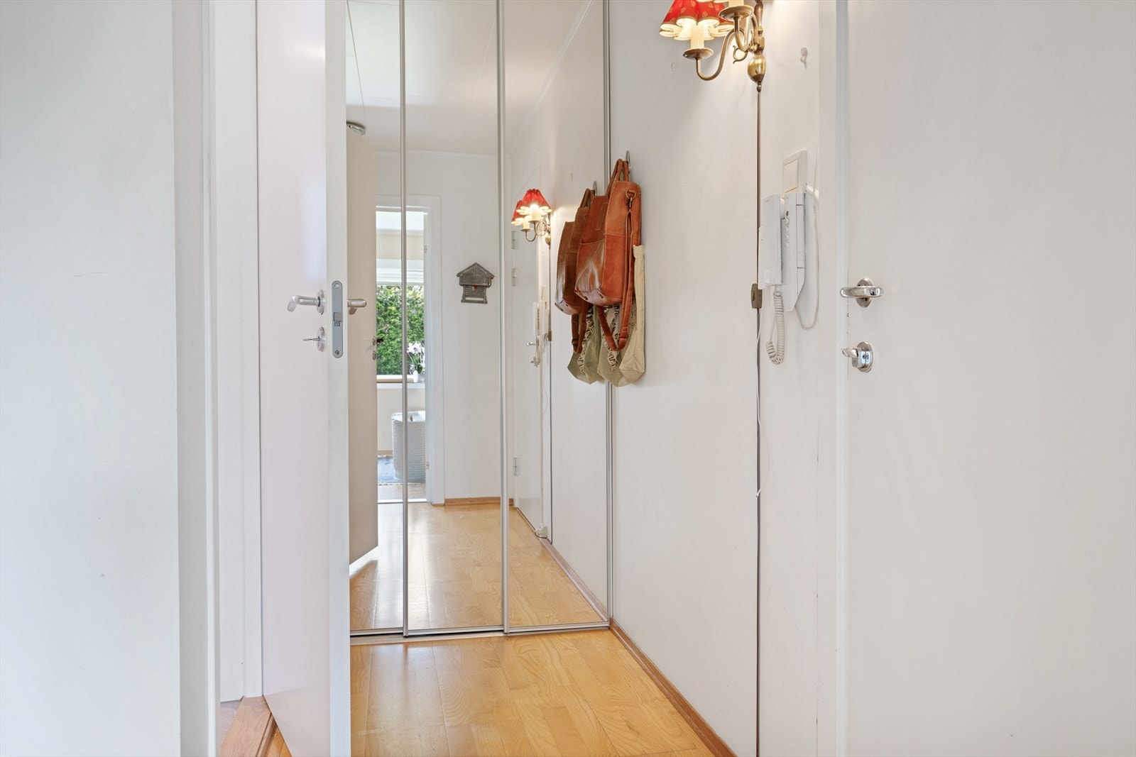 Velkommen inn i en lys og trivelig entré med takhøy skyvedørsgarderobe med speilfronter. Med porttelefon kan du enkelt slippe gjester inn, samtidig som du har full kontroll på hvem som ringer på døren. Galleribilde