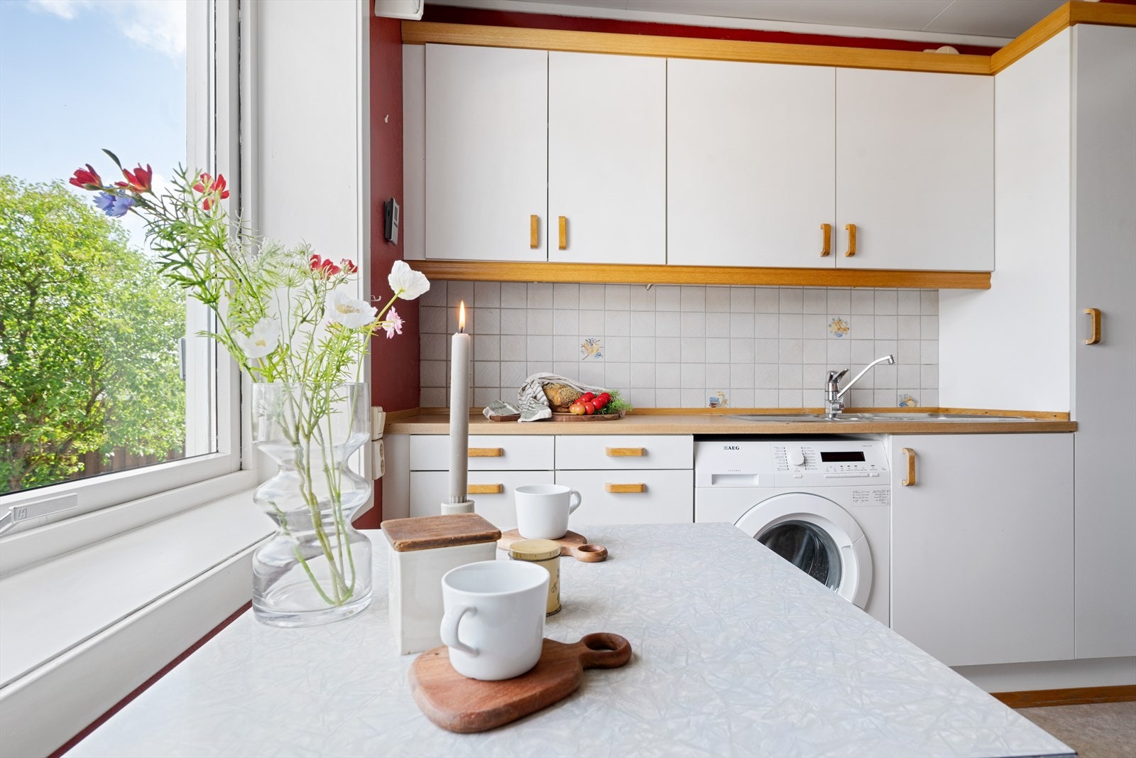Kjøkkeninnredning med tidløse, lyse og slette fronter. Det er avsatt plass for oppvaskmaskin, men plassen benyttes i dag til vaskemaskin i stedet. Galleribilde