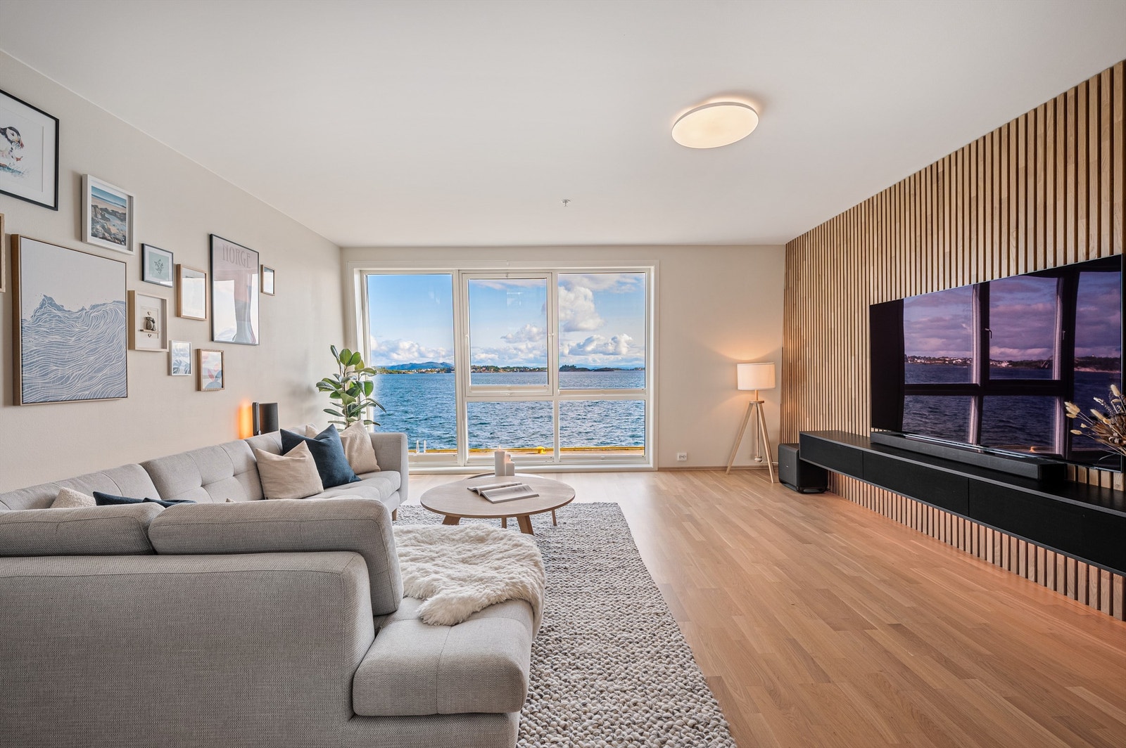 Fra stuen er det fantastisk sjøutsikt og utsikt mot fjellene. Her er det bare å senke skuldrene og nyte det maritime livet utenfor. Stilig spilevegg gir en kontrast i det store lyse rommet. Galleribilde