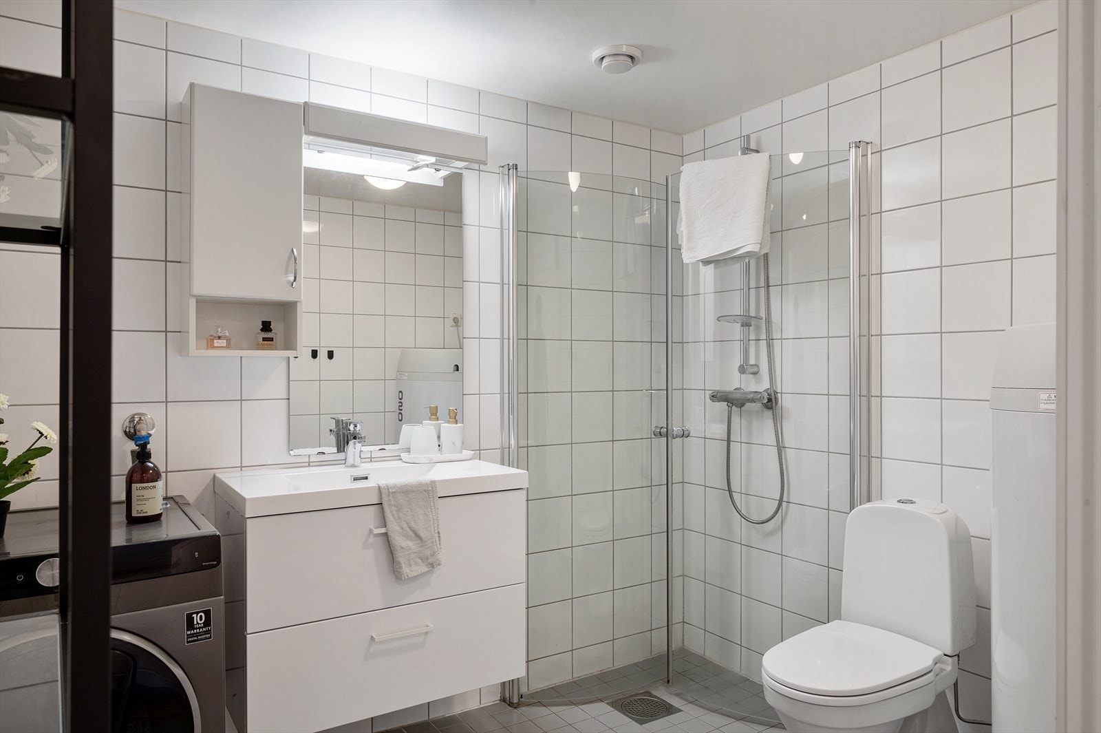 - Badet inneholder benkeskap med servant, dusjdører og gulvmontert toalett - Galleribilde