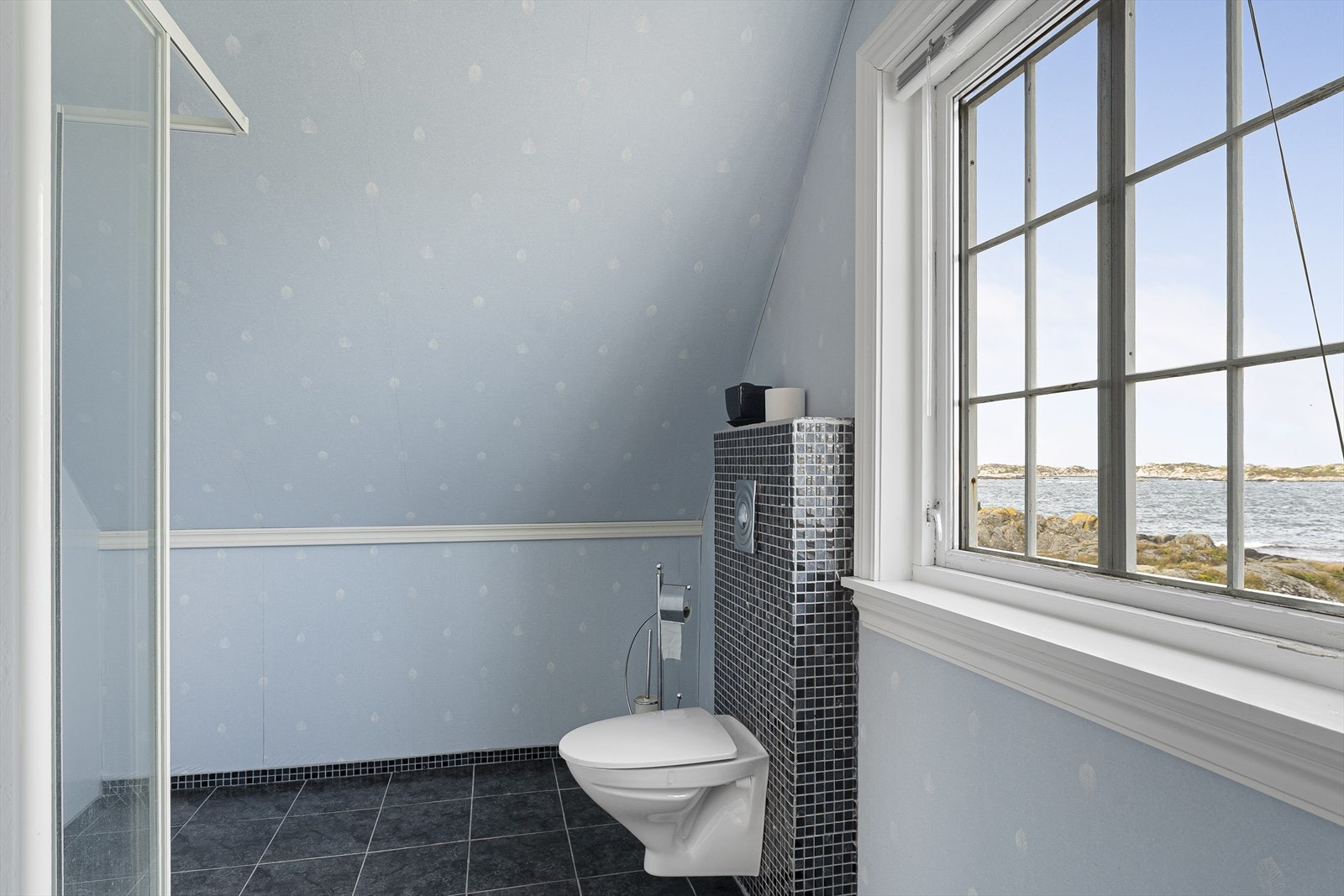 Rommet har fliser på gulv og deler av veggoverflatene. Det er varmekabel i gulvet. Galleribilde