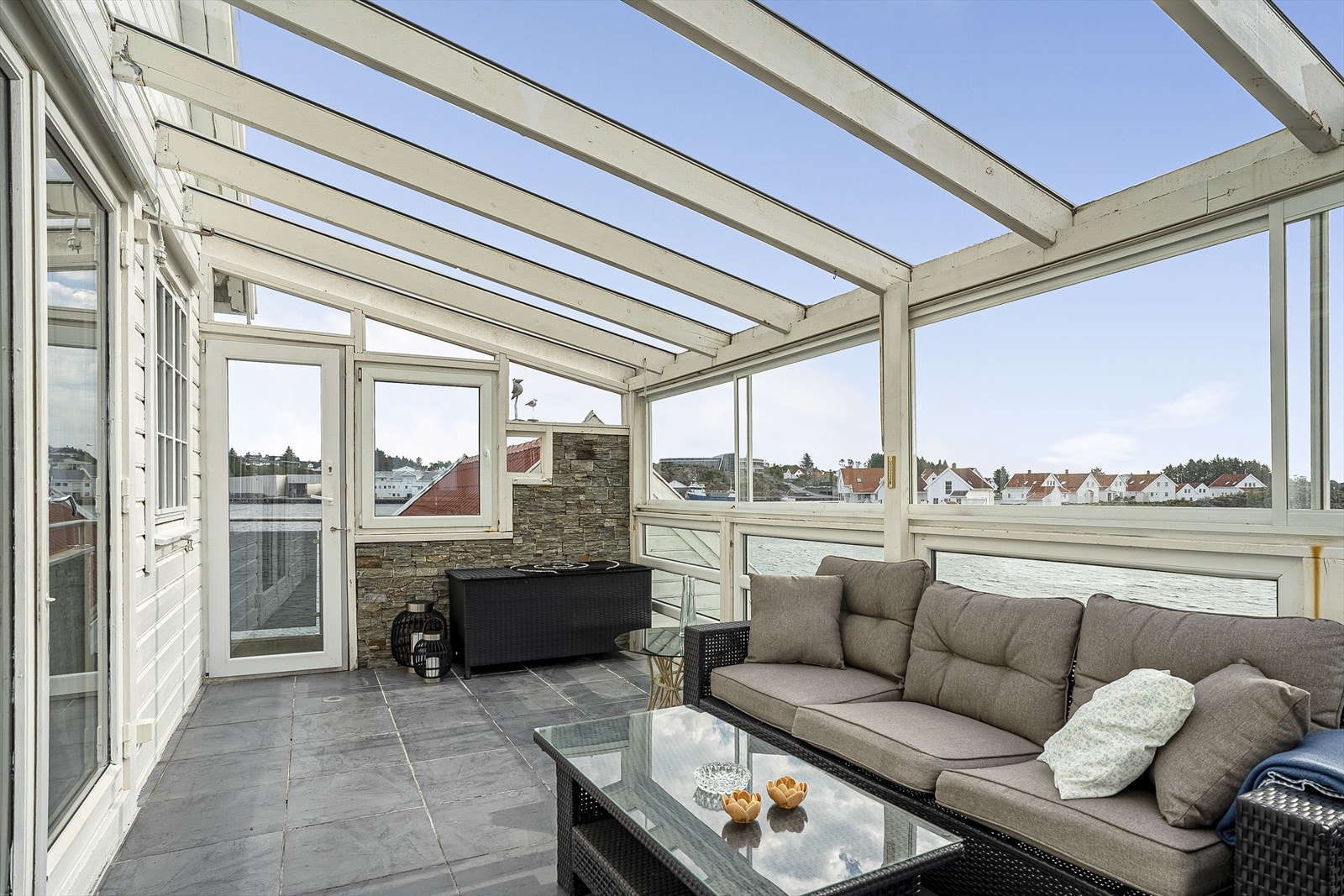 Fra rom innredet som stue er det utgang til en stor hagestue med plass til utemøbler og potteplanter. Galleribilde