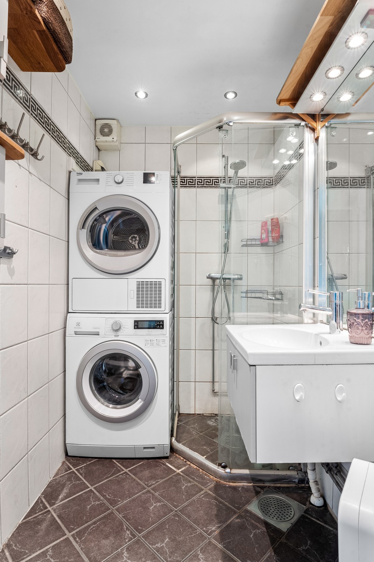 Mellom stue og kjøkken er det adkomst til bad/vaskerom. Badet er flislagt og har gulvvarme. Det er montert downlights i taket, som gir jevn belysning. Galleribilde