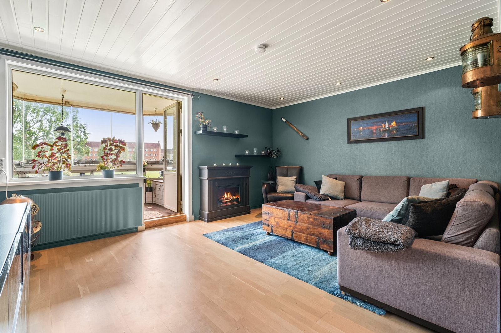 Utgangen til en innglasset balkong gir ekstra bruksmuligheter og naturlig lysinnslipp fra store vindusflater Galleribilde