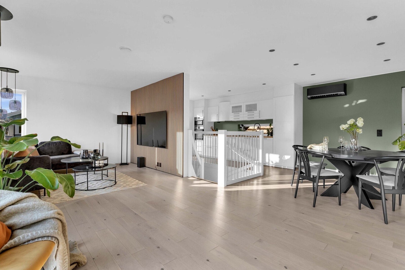 Stuen ligger i åpen løsning med spisestuen og kjøkkenet, og sammen danner de et stort, luftig og innbydende allrom som dekker hele første etasje. Galleribilde