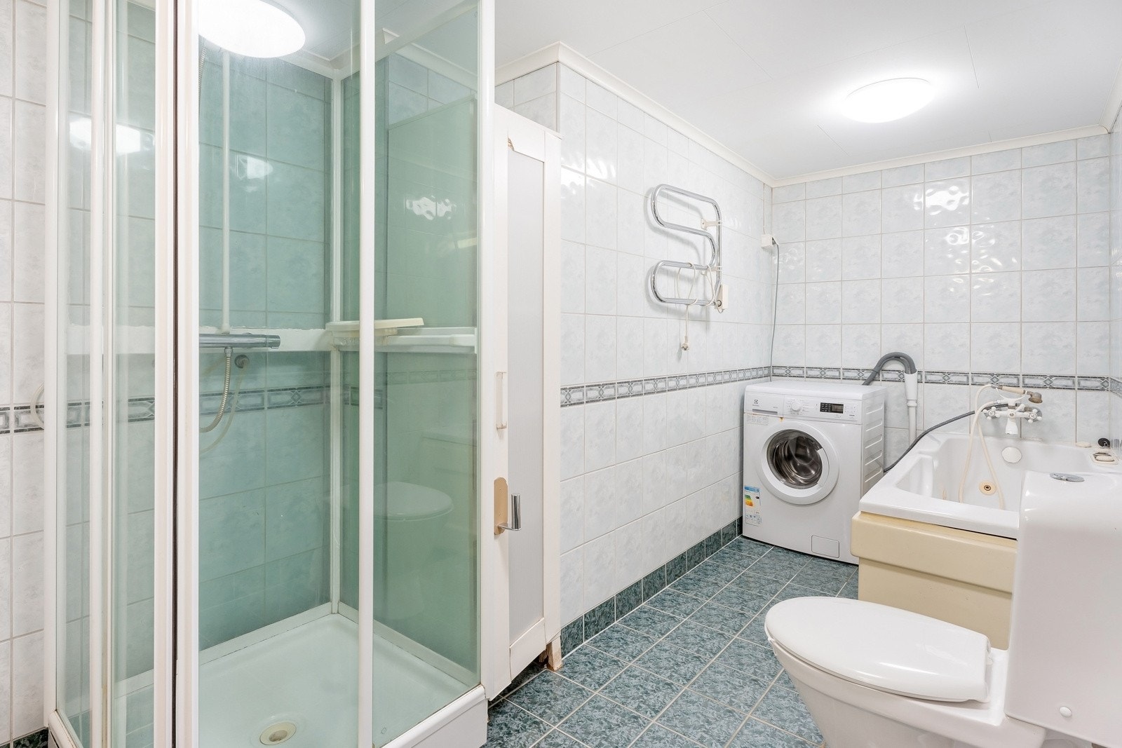 Bad innredet med dusjkabinet, badekar, servant og WC. Galleribilde