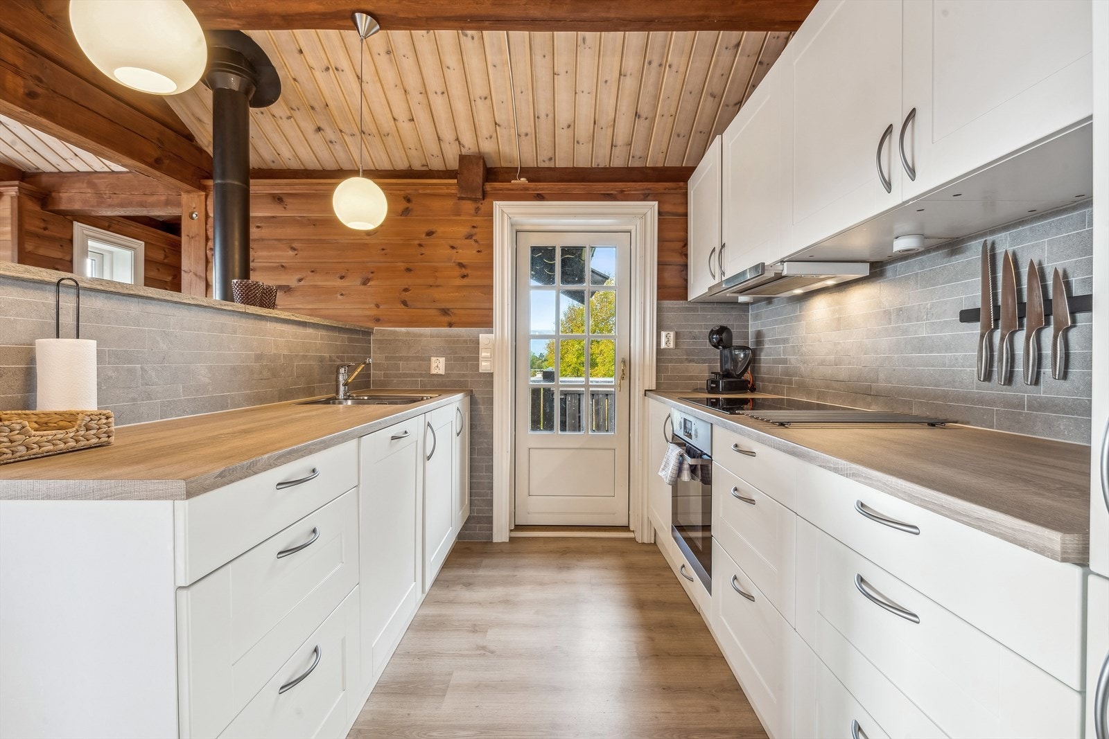 Et godt arbeidskjøkken med lys kjøkkeninnredning og integrerte hvitevarer Galleribilde