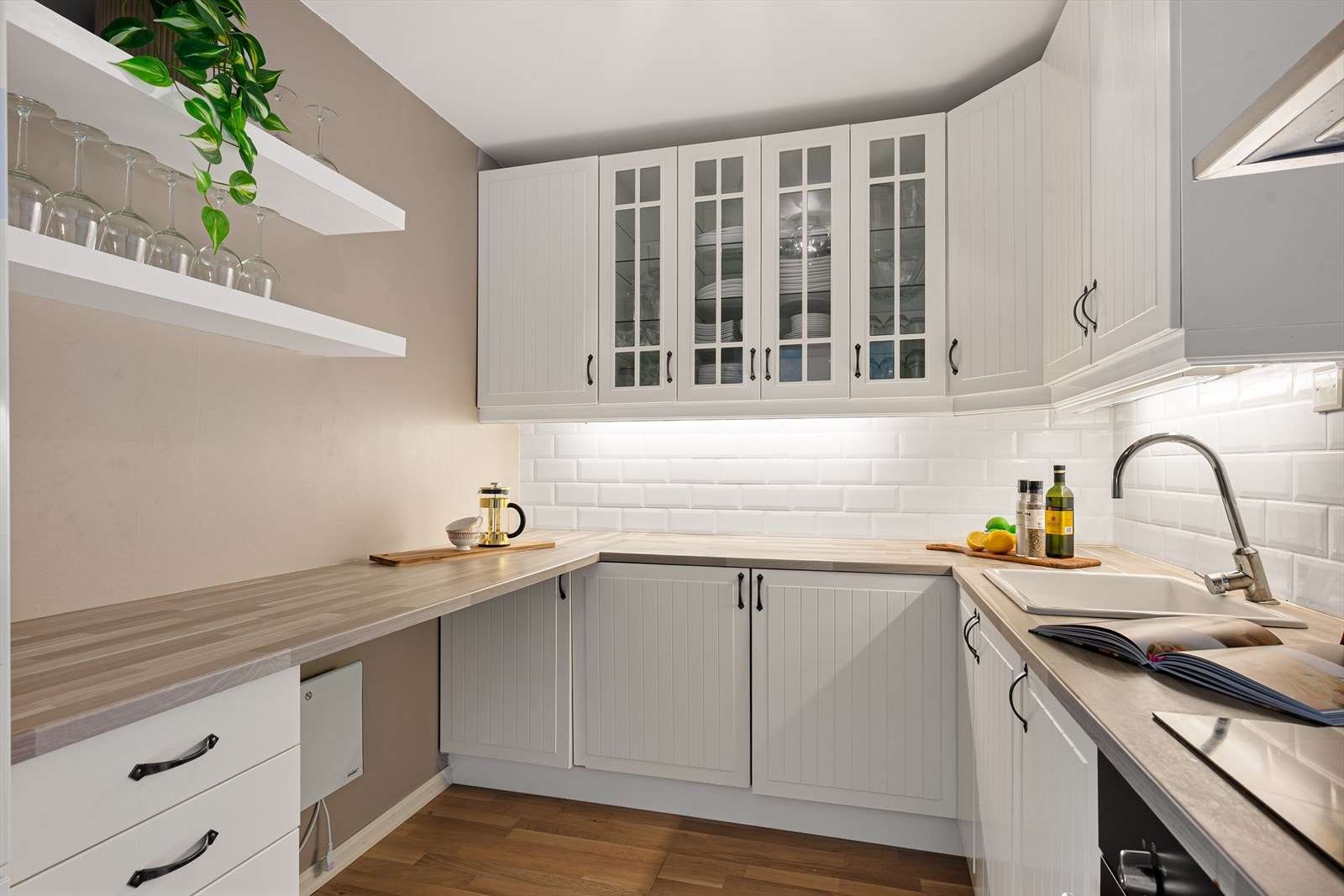 Kjøkkeninnredning fra Ikea med klassisk, profilerte fronter og vitrineskap. Kjøkkenet har gode arbeidsflater og rikelig med oppbevaring i skap og skuffer. Galleribilde