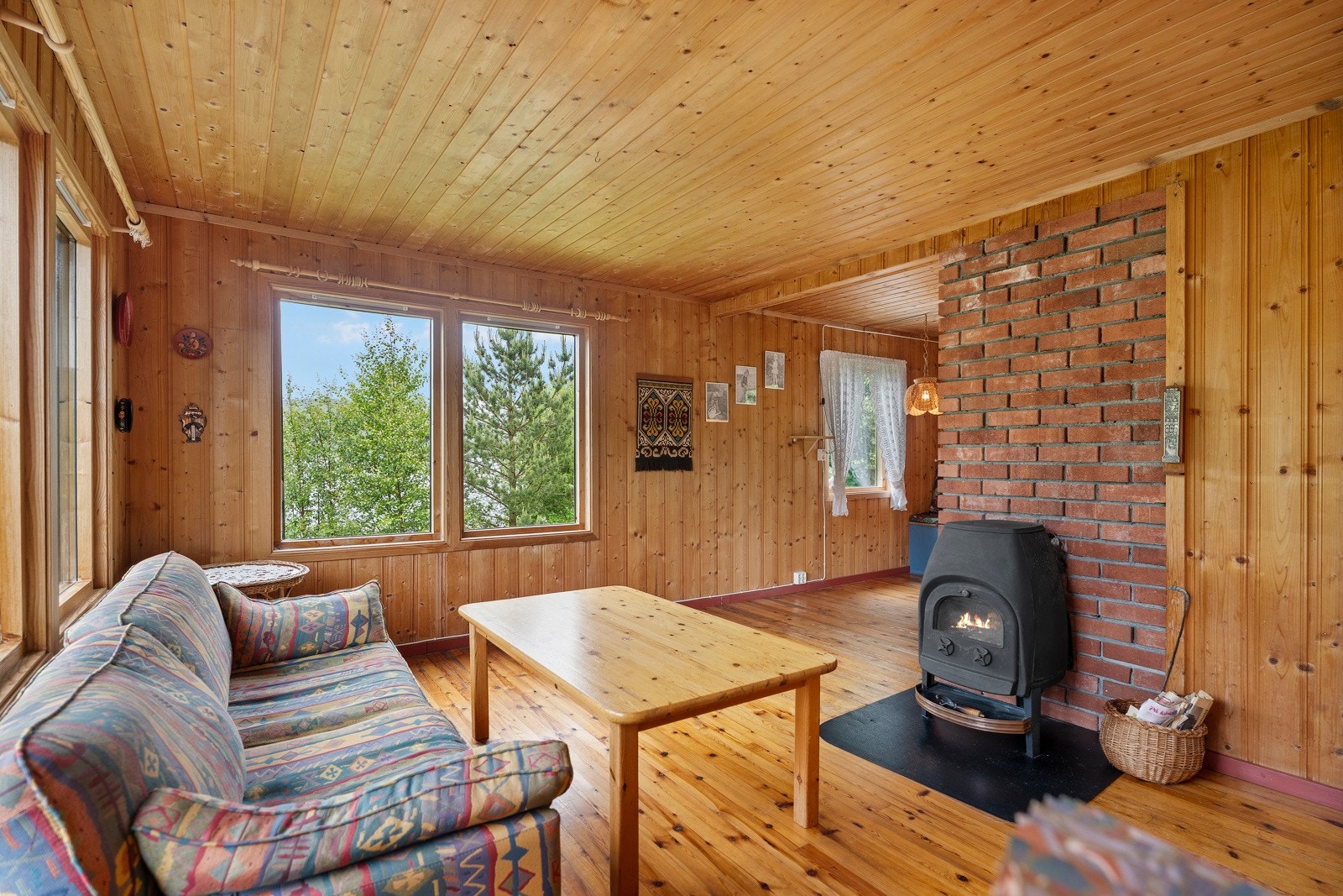Koselig stue med tregulv og panel. Det er flott utsikt fra stuen. Galleribilde