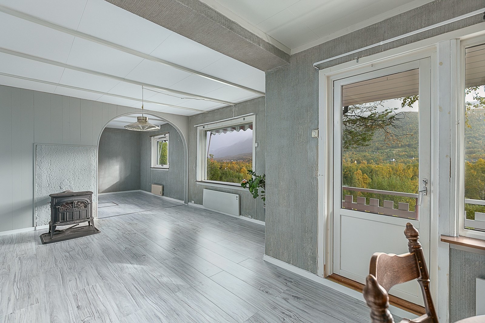 Romslig stue med vedfyring og utgang til veranda. Galleribilde