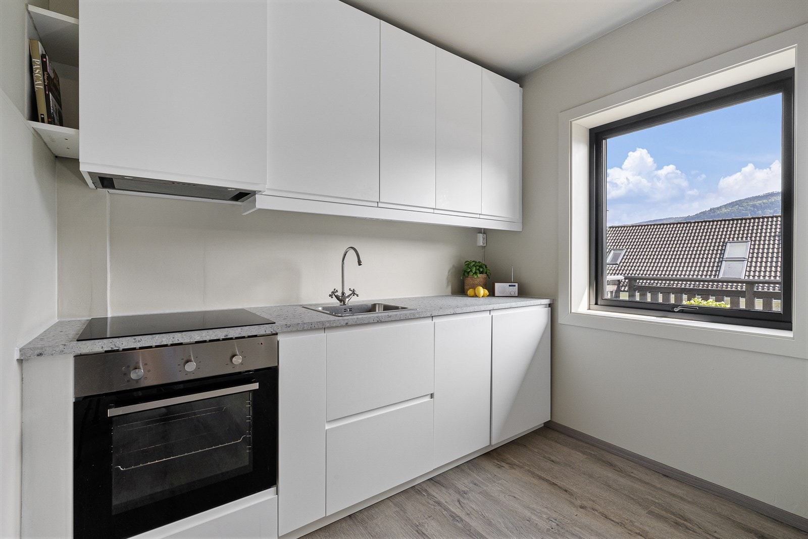 Lekkert kjøkken med integrerte hvitevarer. Ny benkeplate i 2025 og ny oppvaskmaskin i 2024. Galleribilde