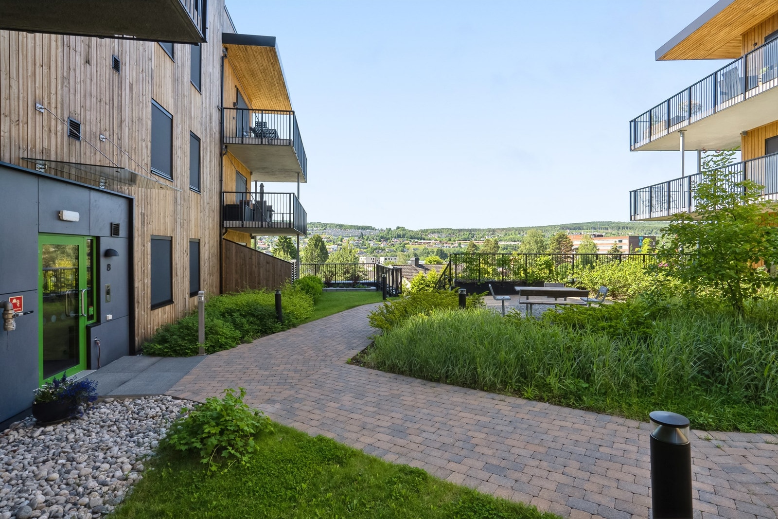 Velstelt fellesområde med grønne omgivelser og hyggelige sittesoner for beboerne. Galleribilde