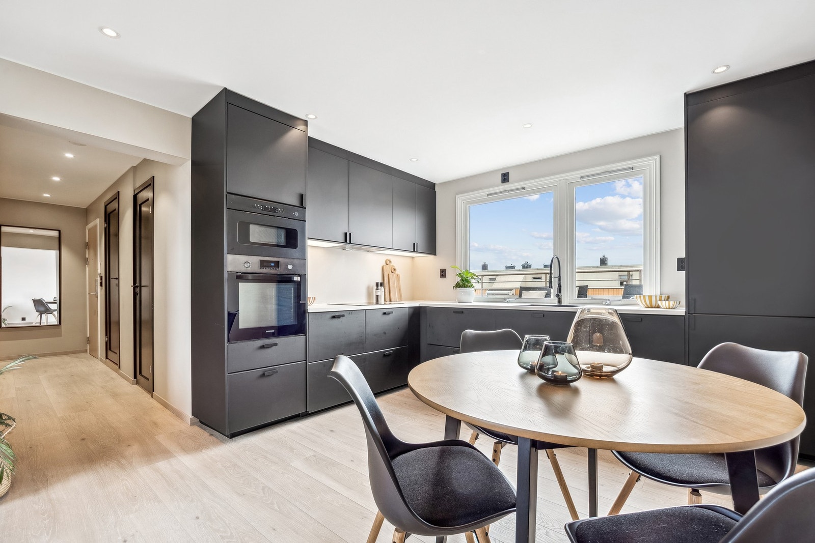 Stilrent og moderne kjøkken med sorte, glatte fronter og lys benkeplate som gir en elegant kontrast - oppgradert i 2021 og vurdert til tilstandsgrad TG1. Galleribilde